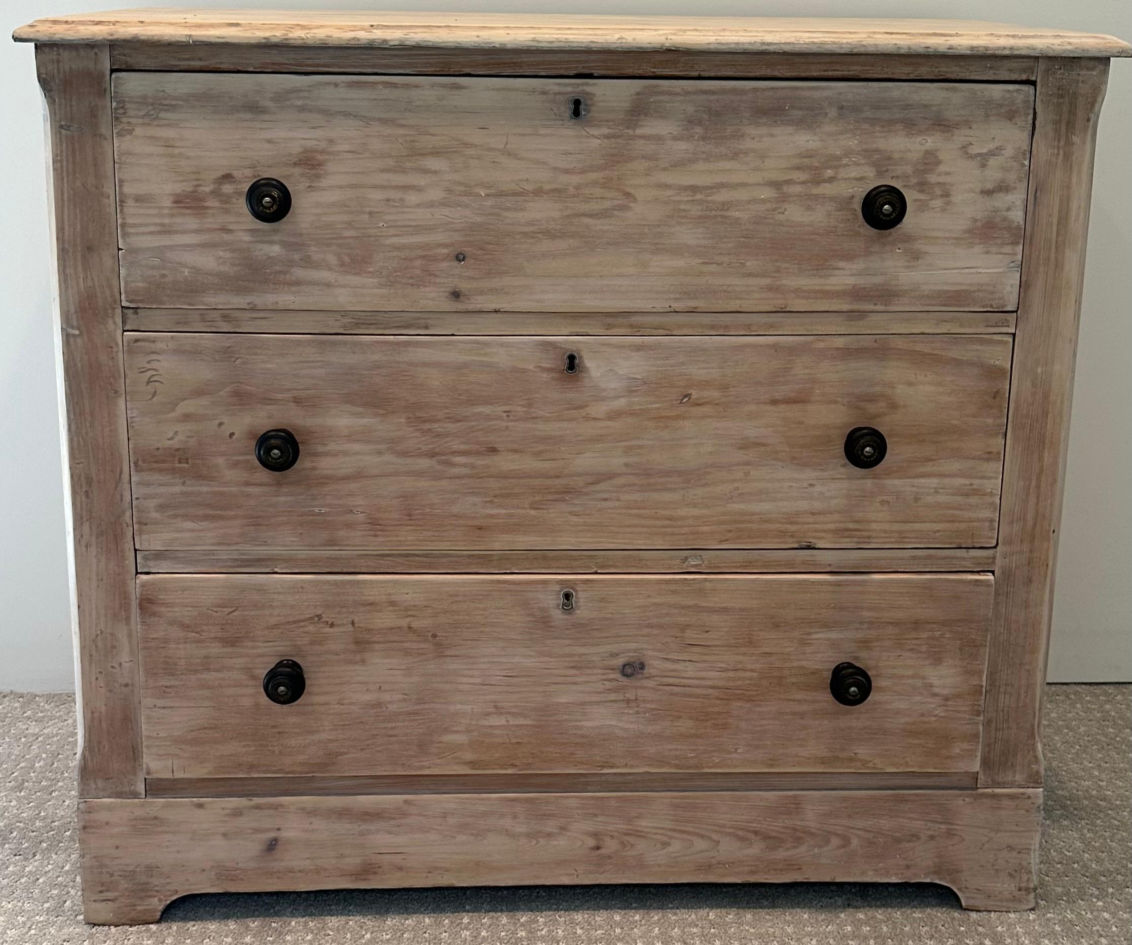 Charming and useful, this lovely rustic country style 3 wide drawer chest dates to the 19th century. The wood has been white washed to give it added interest and is accented perfectly by the darker metal iron knobs. This chest would make an
