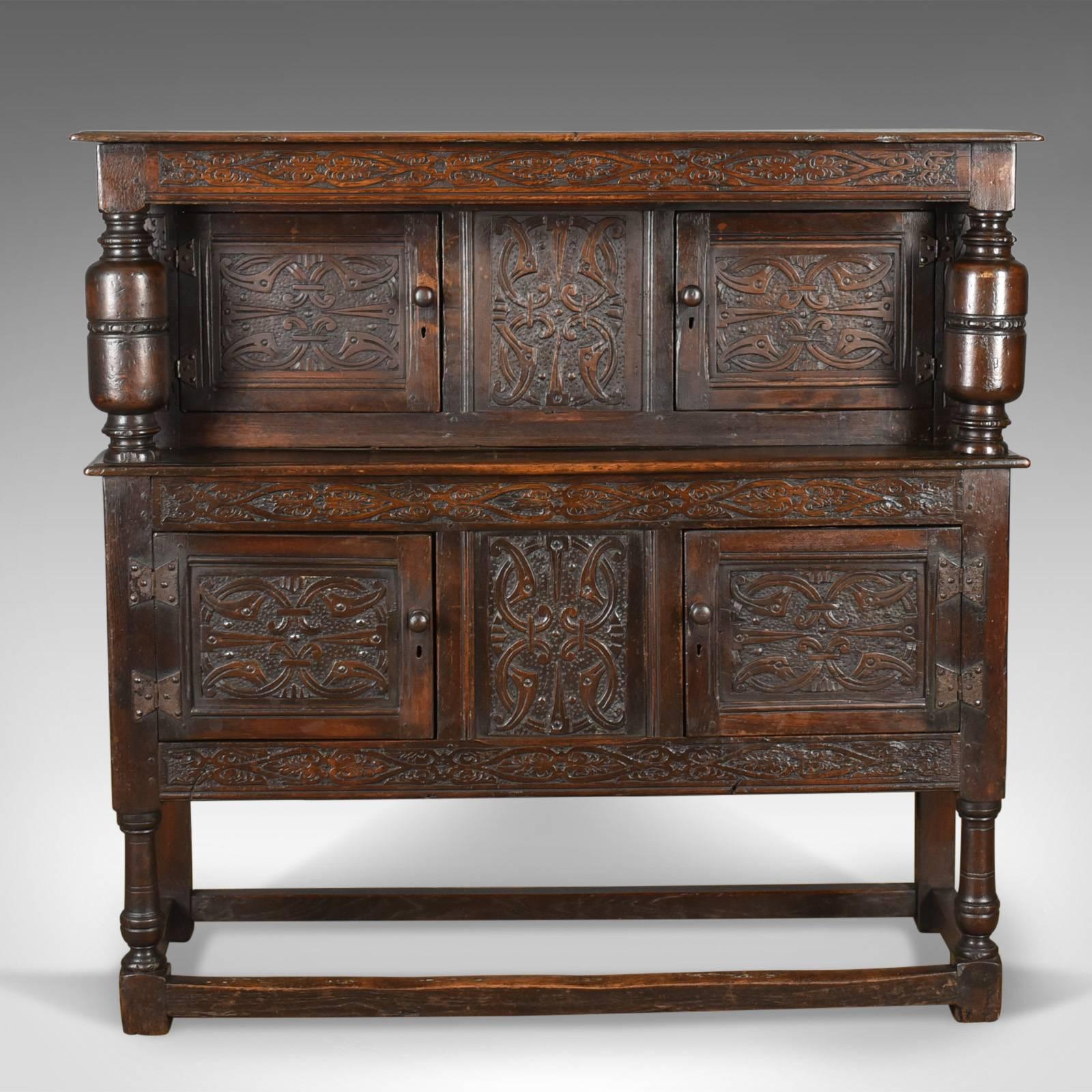 This is an antique court cupboard, a late Georgian, English oak sideboard in the Jacobean taste dating to circa 1800.

Deep, rich tones to the English oak
Desirable aged patina in a wax polished finish
Mid-sized and profusely decorated with