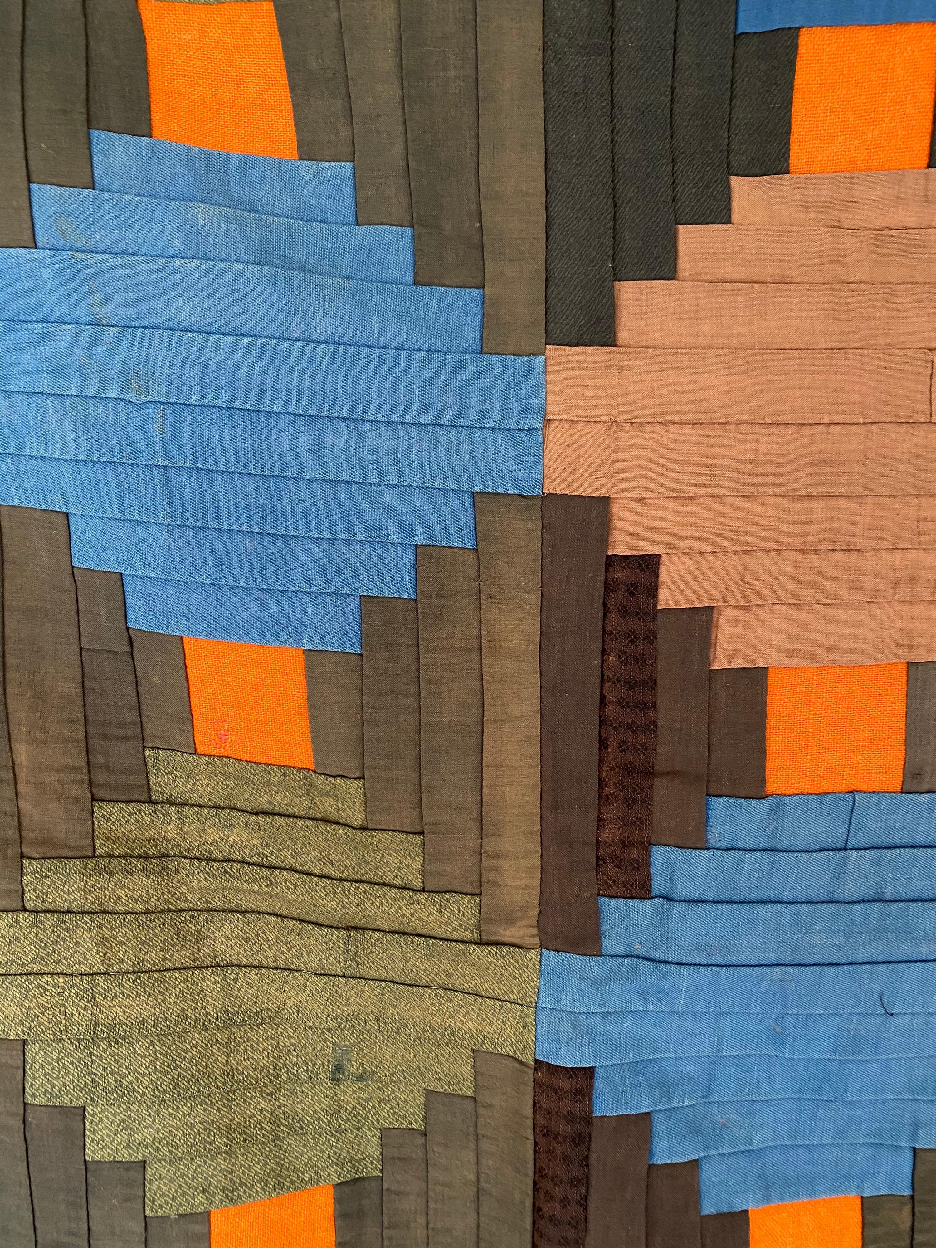 Antique courthouse steps quilt in blue, tan, taupe, and orange on a dark green background. This antique piece translates well in a modern setting with its geometric shapes and colors.