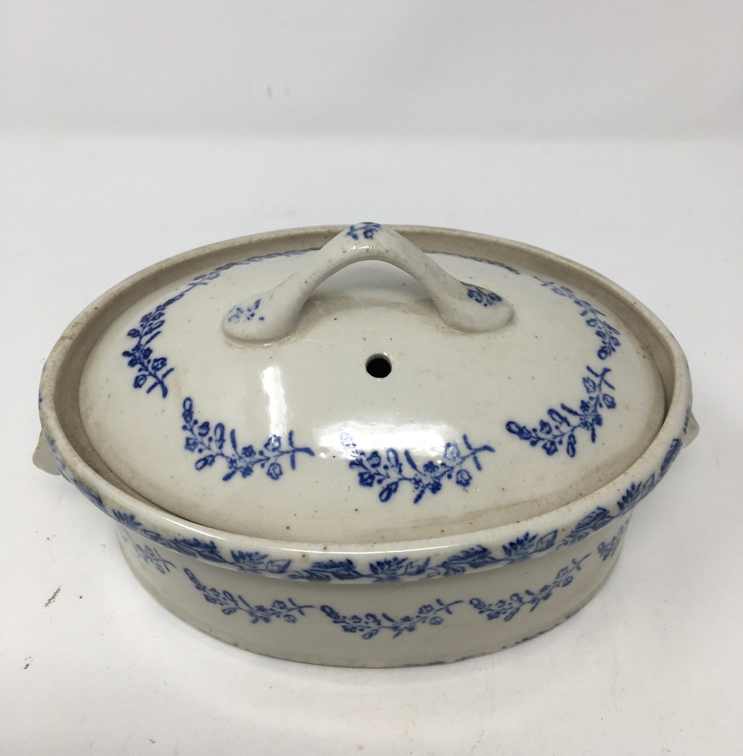 Found in France, this antique ironstone covered casserole dish has lovely blue floral transferred design. The piece is complete with a pull handle on the lid and two handles on the casserole itself. Stamped Marque Deposte on the bottom, this
