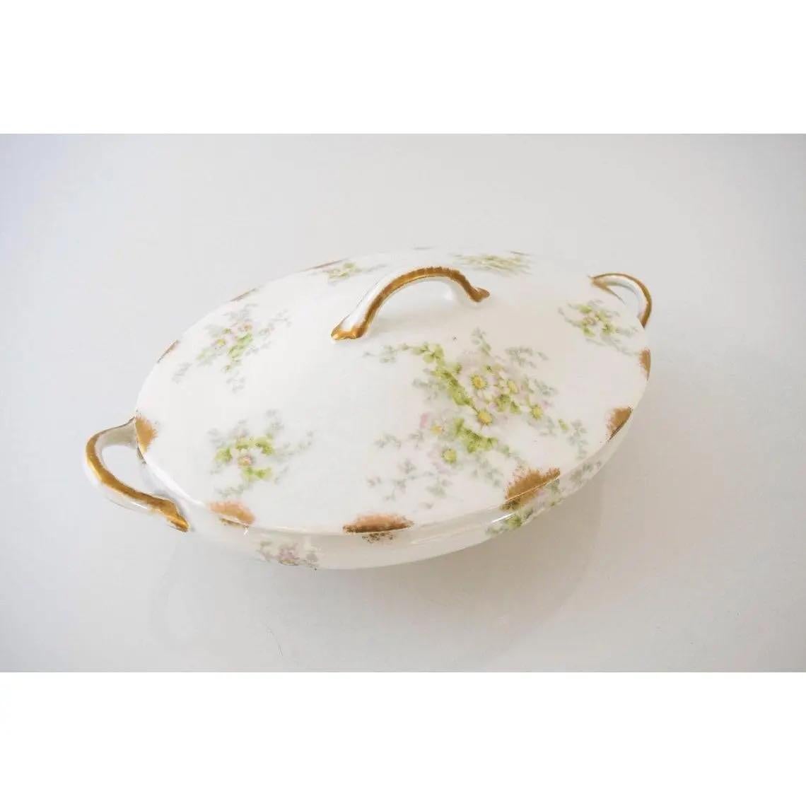 This lovely vintage antique Haviland Limoges GDA France covered serving tureen or vegetable bowl is circa 1900-1941. It features a translucent white background decorated with a soft, delicate floral pattern of pale green leaves and vines and pink