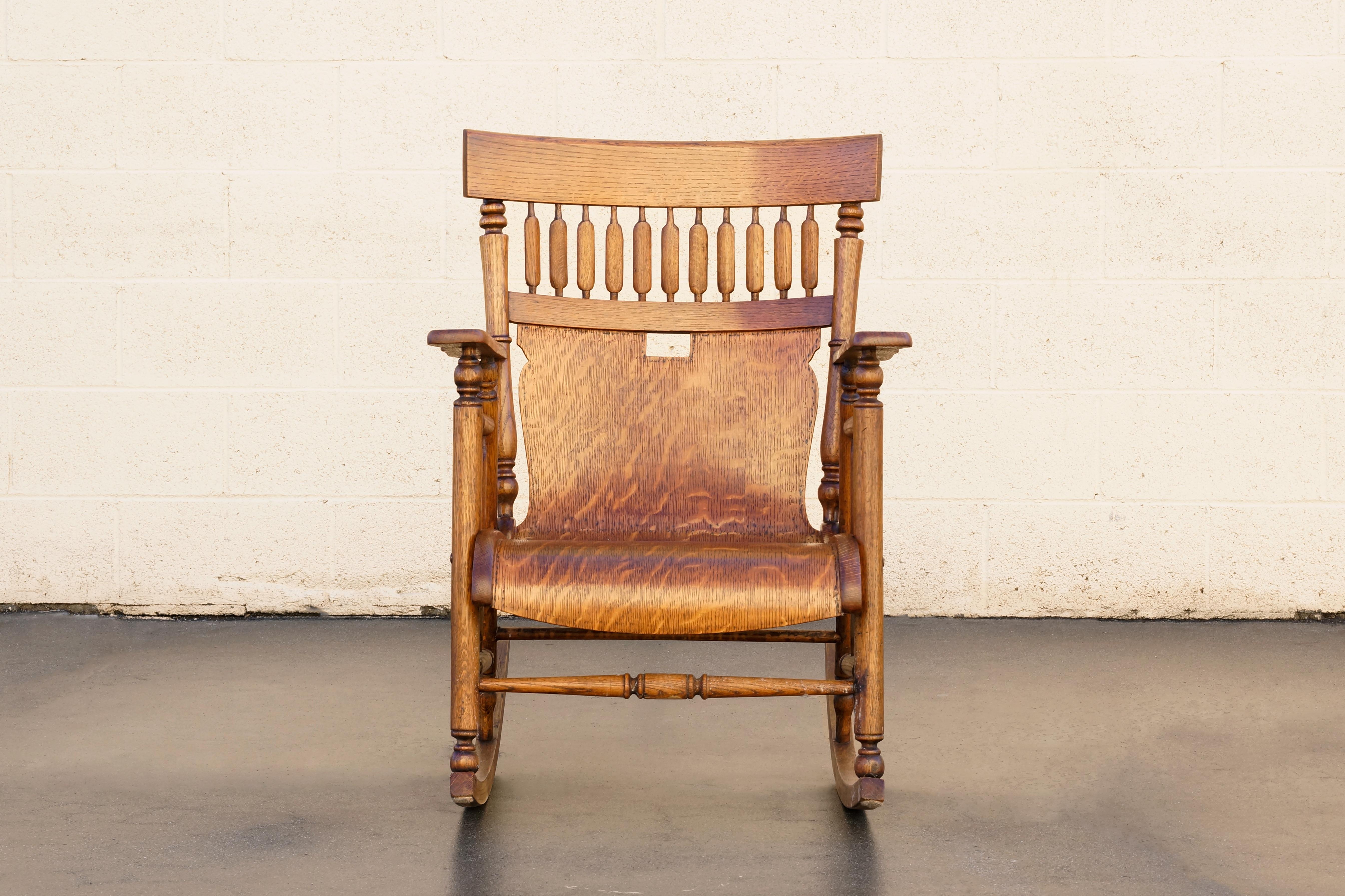 Remarkable rocking chair of the Craftsman/ Windsor style. Composed of oak with short arrow back spindles and solid bentwood seat. Outstanding grain, color and patina, lightly reconditioned to bring out its natural glow. In excellent antique