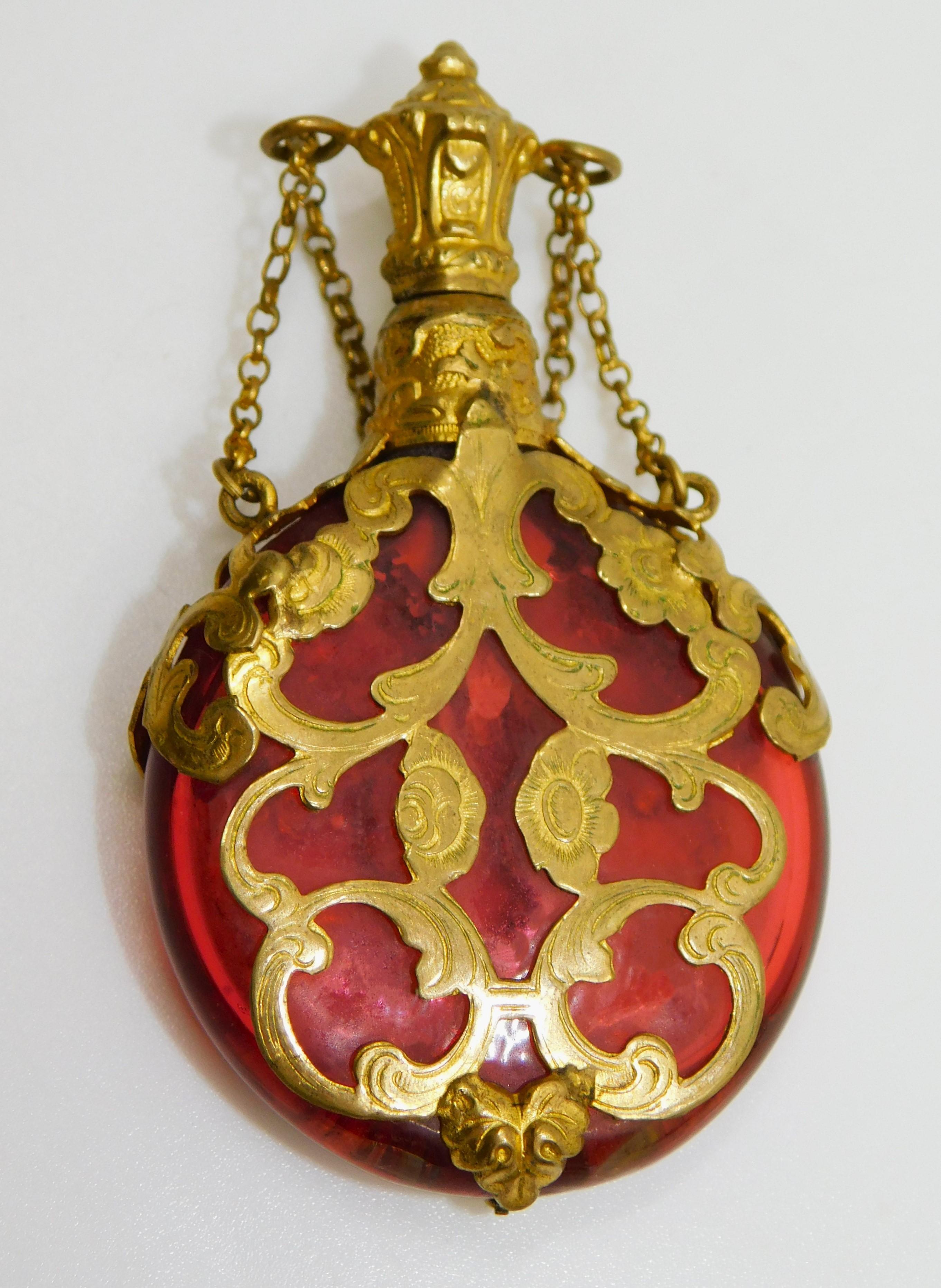 This beautiful late 19th Century antique red cranberry glass, gold overlay filigree perfume or scent bottle comes with original stopper top/lid and chain.  In great condition, (stand not included).