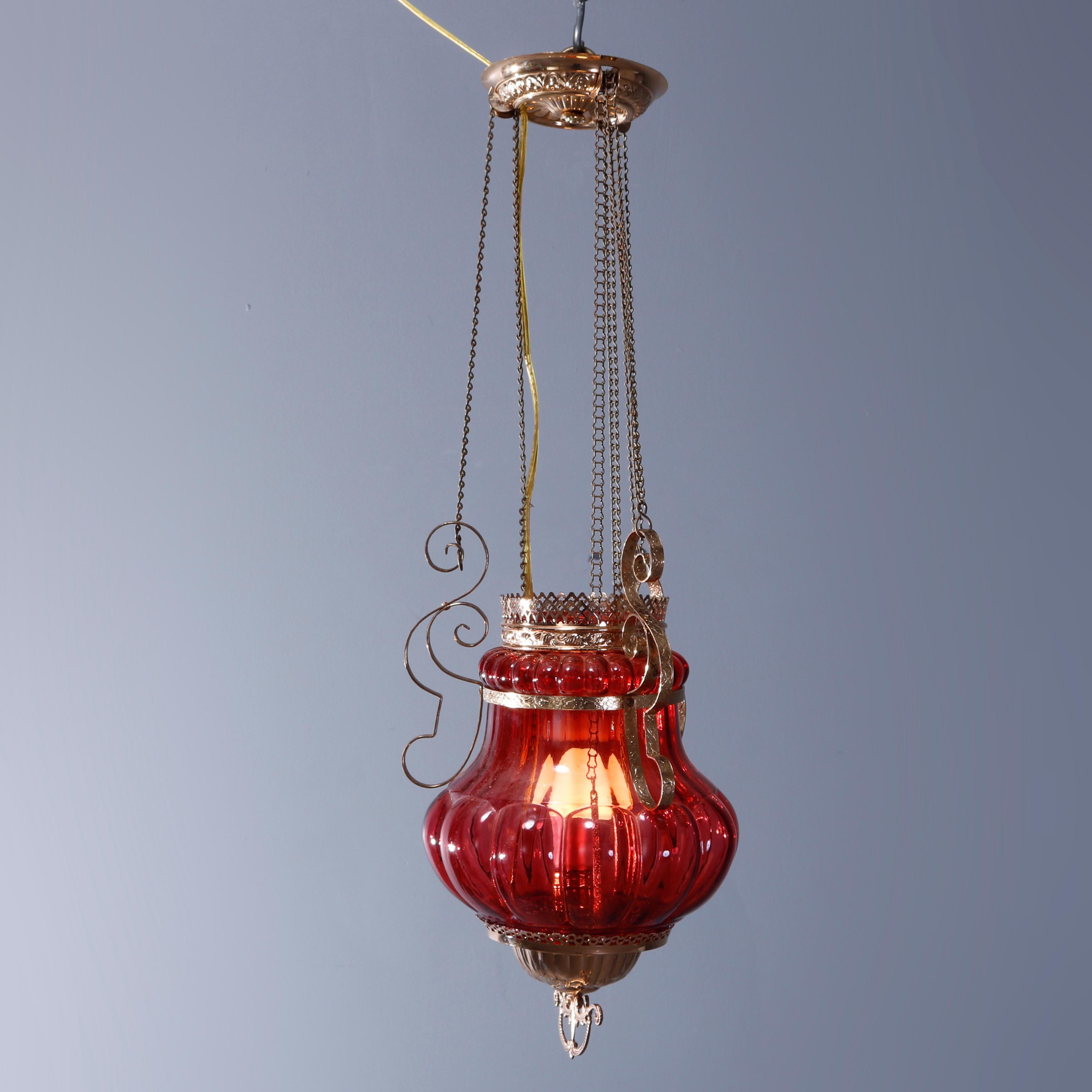 An antique pendant hall light offers cranberry glass bulbous globe in frame having scroll and foliate elements and hanging from three drop chains, reminiscent of Persian styling, c1890

Measures - 28''H x 8.5''W x 8.5''D.

Catalogue Note: Ask about