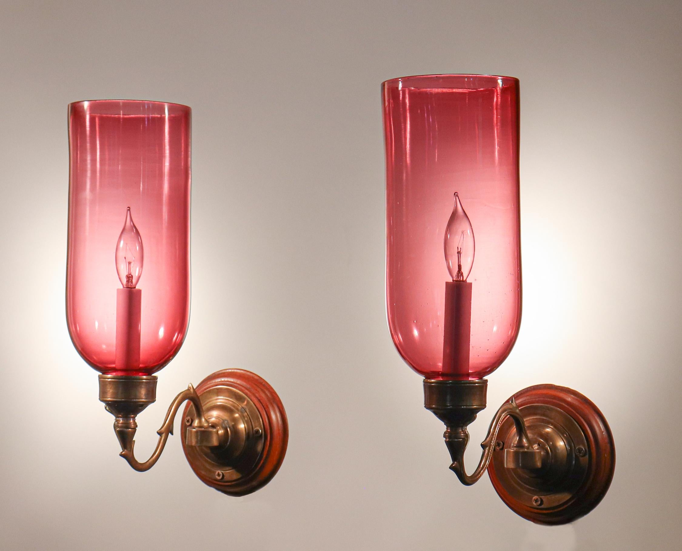 A beautiful pair of English cranberry glass hurricane sconce shades with straight form and excellent quality hand blown glass. Originally for candles, the sconces have been newly electrified, each taking a single candelabra bulb accommodating up to