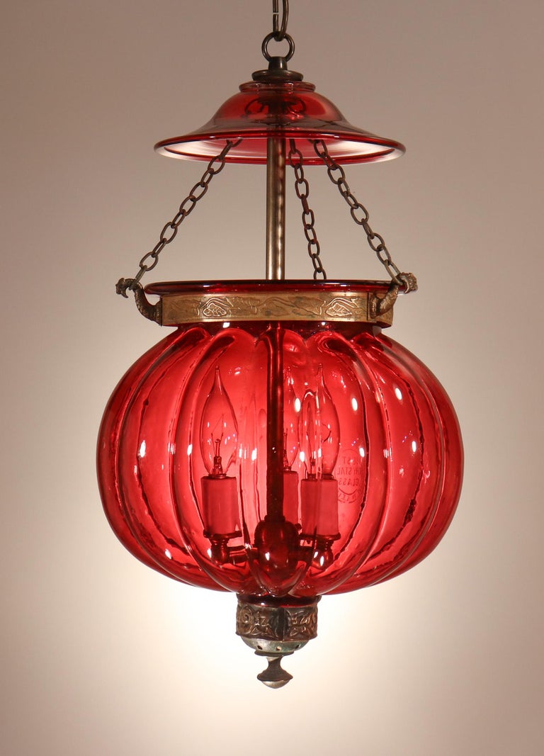 A rare cranberry-colored melon- or pumpkin-shaped bell jar lantern from Belgium, circa 1890. The color is in the cranberry family, but is closer in hue to that of a Burmese ruby. The hand blown glass is of very good quality, and features the imprint