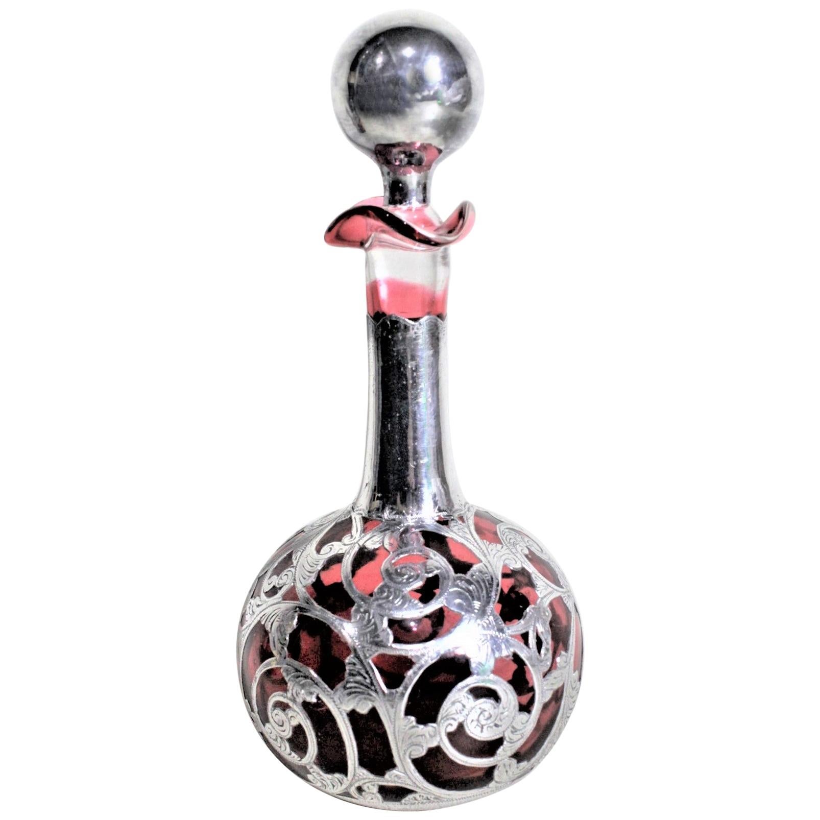 Antiguo frasco de perfume o esencia de cristal de arándano con sobrecapa de plata grabada