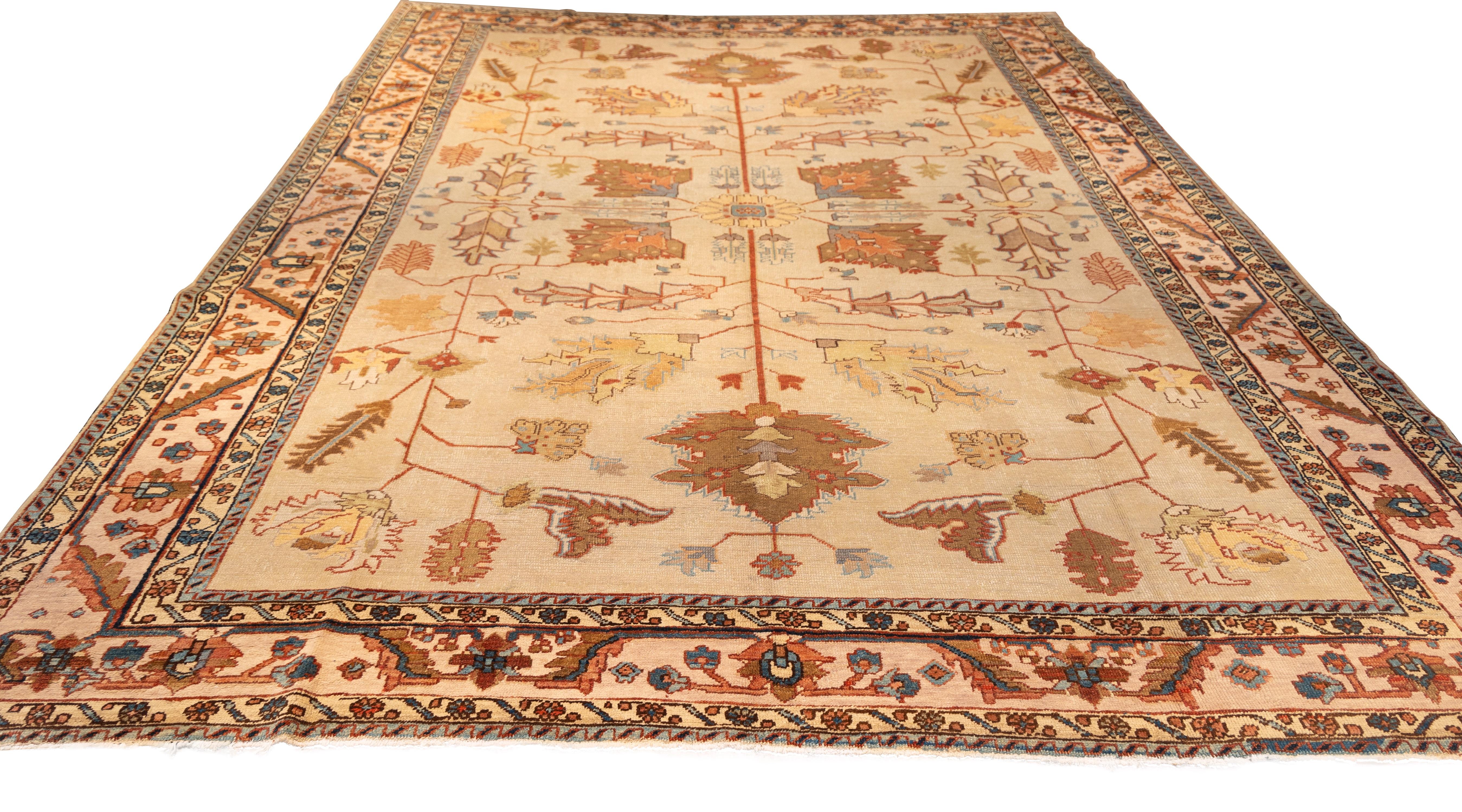 Featuring a refined and symmetric allover design centered around a tree-of-life or floral schematic. The soft ivory ground is adorned with stylized botanical motifs in tones of terracotta, rust, soft gold, and muted gray-blue. The composition is