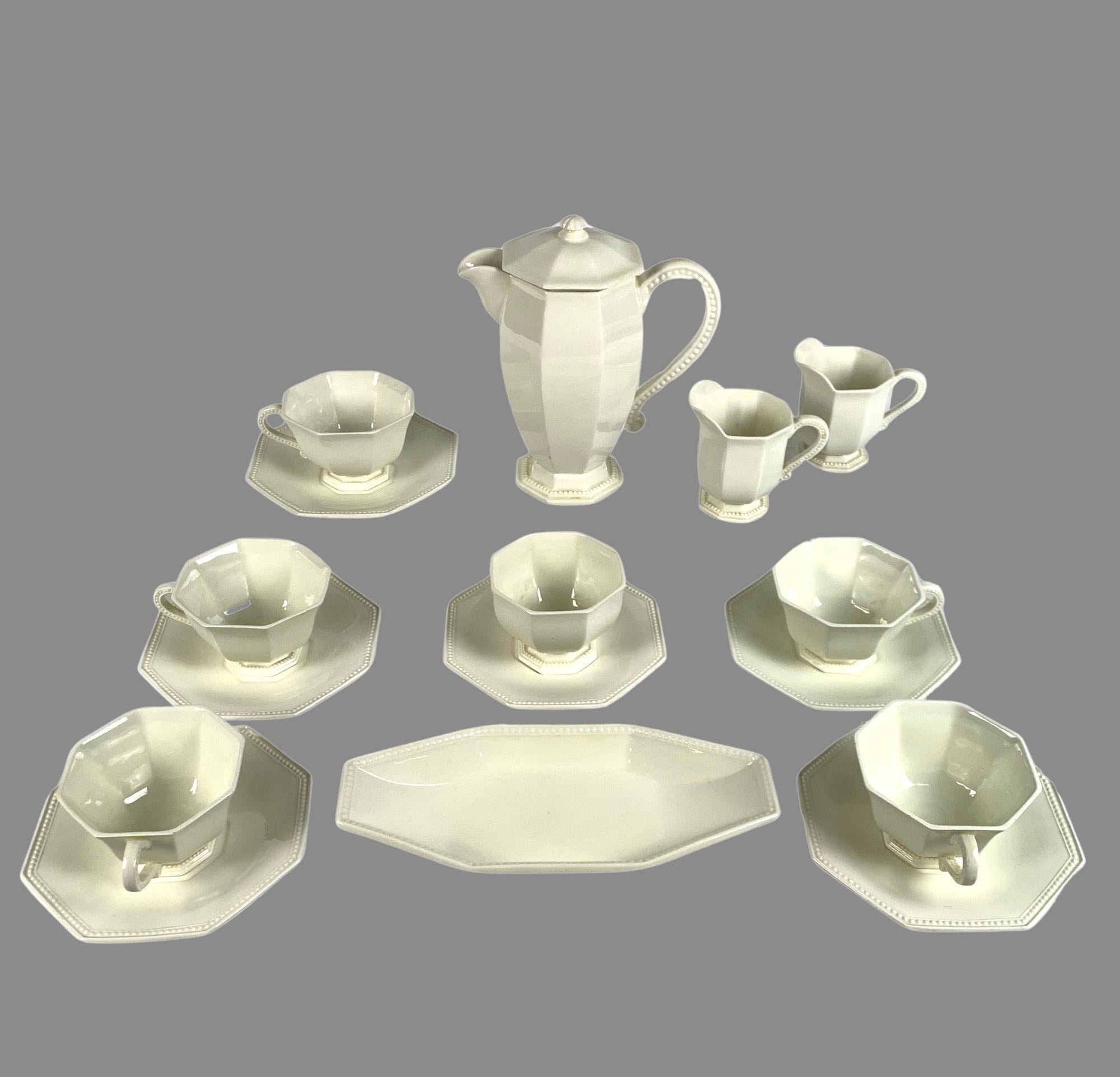 This exquisite French creamware breakfast set comprises five large breakfast cups, an open sucrier with its stand, a coffee pot, two creamers, and a long dish for biscuits or rolls.
Each piece in the set has an elegant octagonal design with a raised