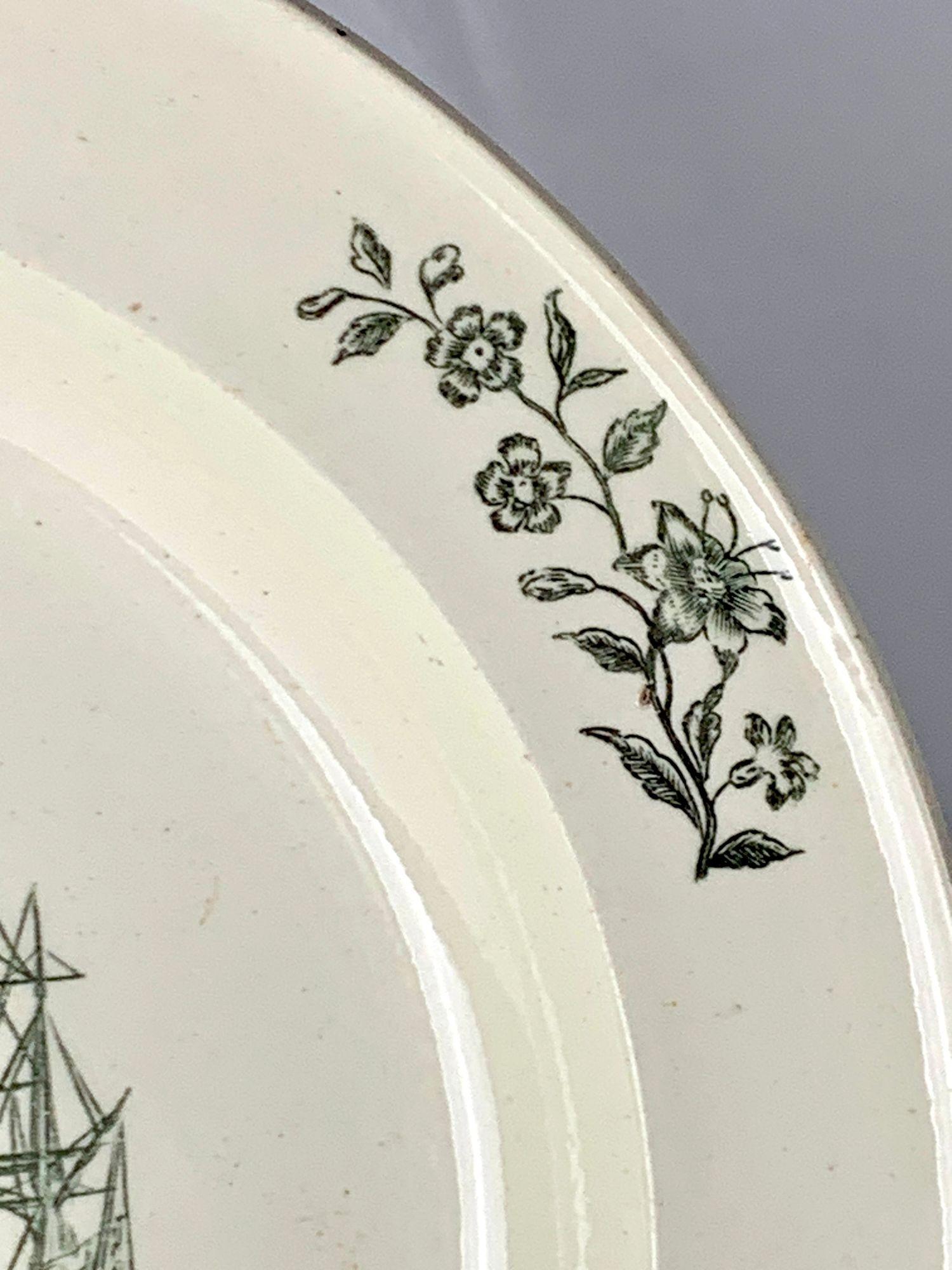 Questo antico piatto in crema è stato realizzato a Liverpool, in Inghilterra, da Herculaneum Pottery, intorno al 1820.
Al centro, una scena stampata a trasferimento intitolata Poor Jack mostra un marinaio che si congeda da una giovane donna, con una