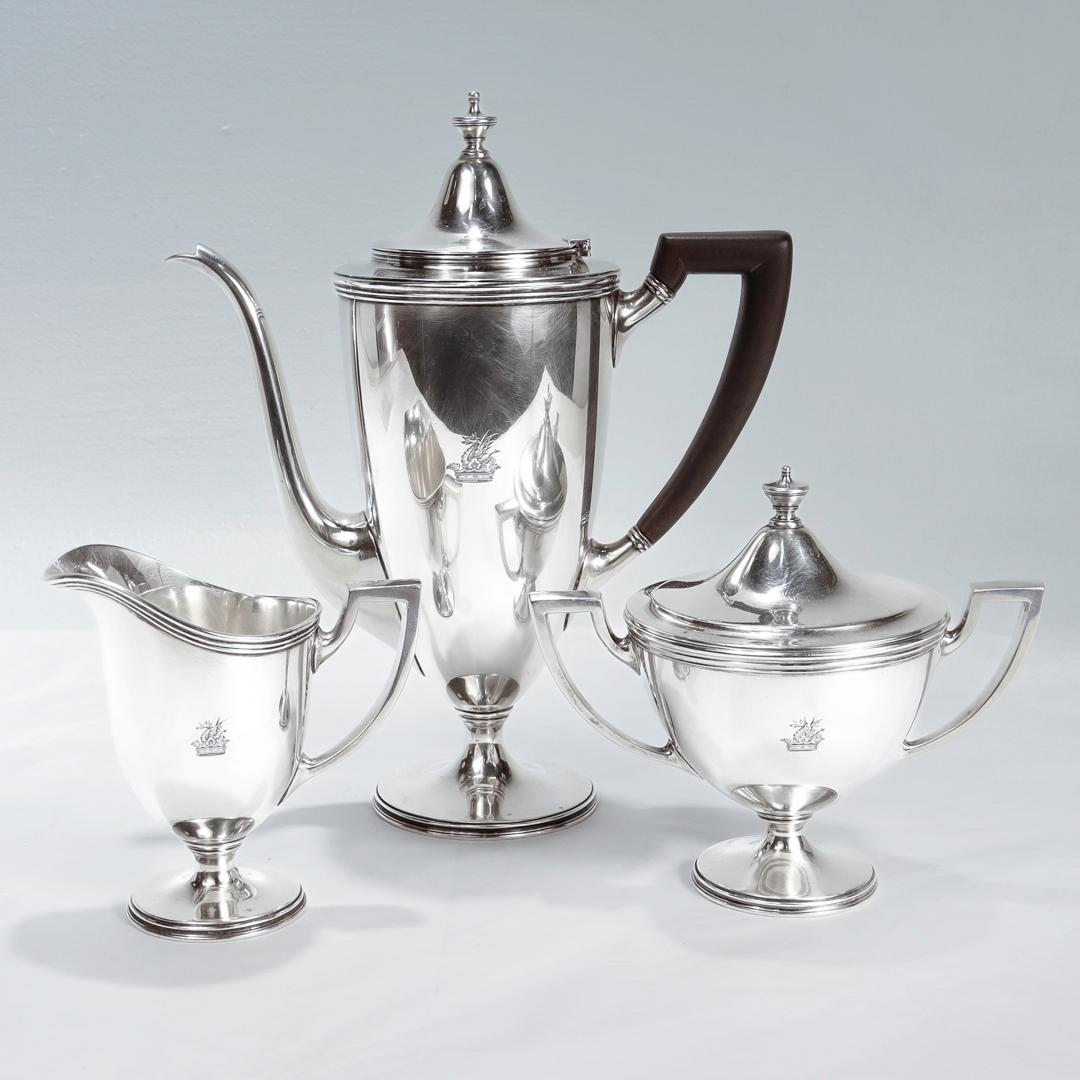 A fine antique crested tea or coffee service.

Comprised of a tall tea or coffee pot with a wooden handle, an open sugar, and a creamer in heavy-gauge sterling silver.

Each of the 3 pieces engraved with a dragon over crown crest.

Fully hallmarked