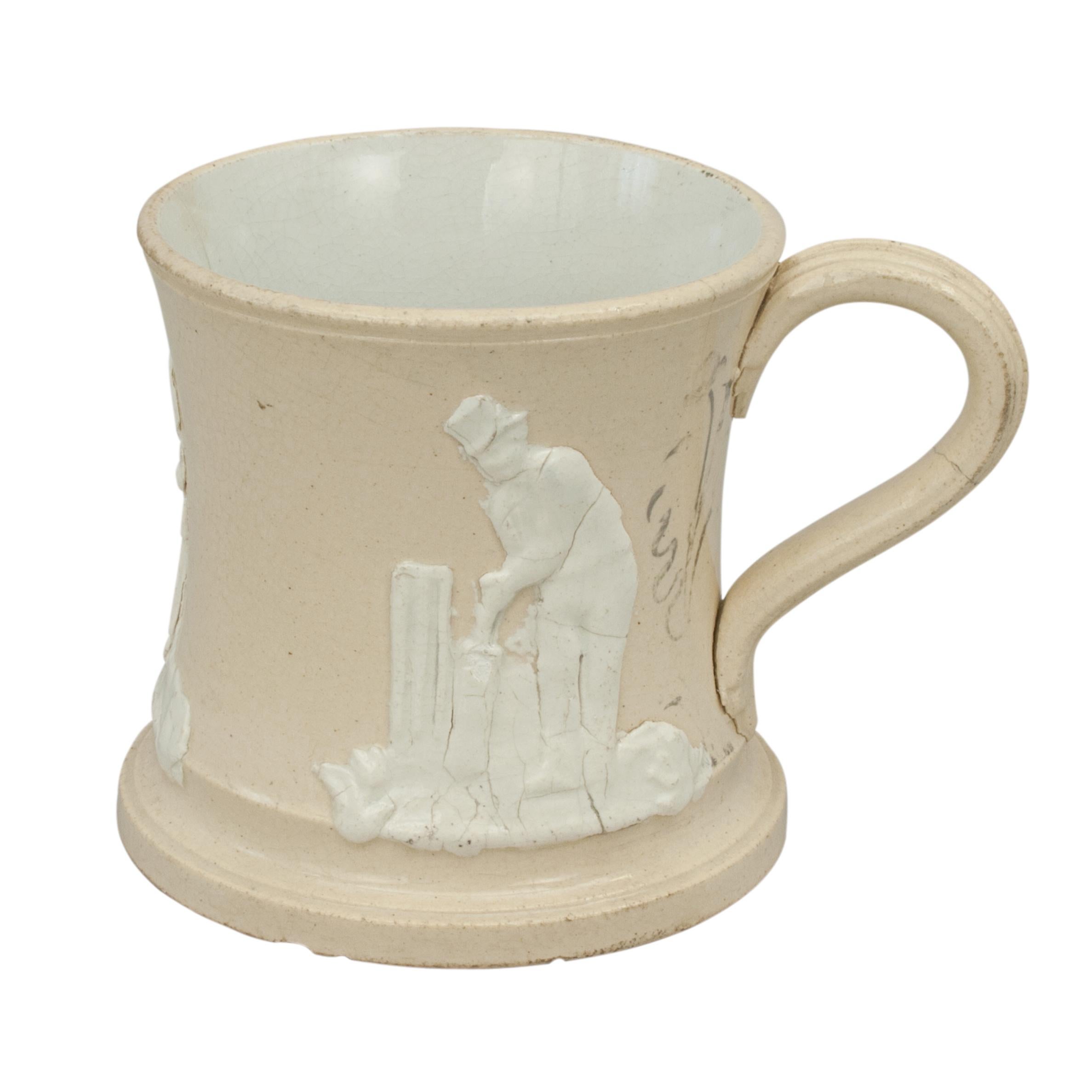 Staffordshire Cricket Mug.
An early Staffordshire Cricket mug, the body in cream colour with three cricketers in white relief around the mug. The three cricketers are all dressed in period costumes, a Batsman, a Bowler and a Wicket Keeper. A nice
