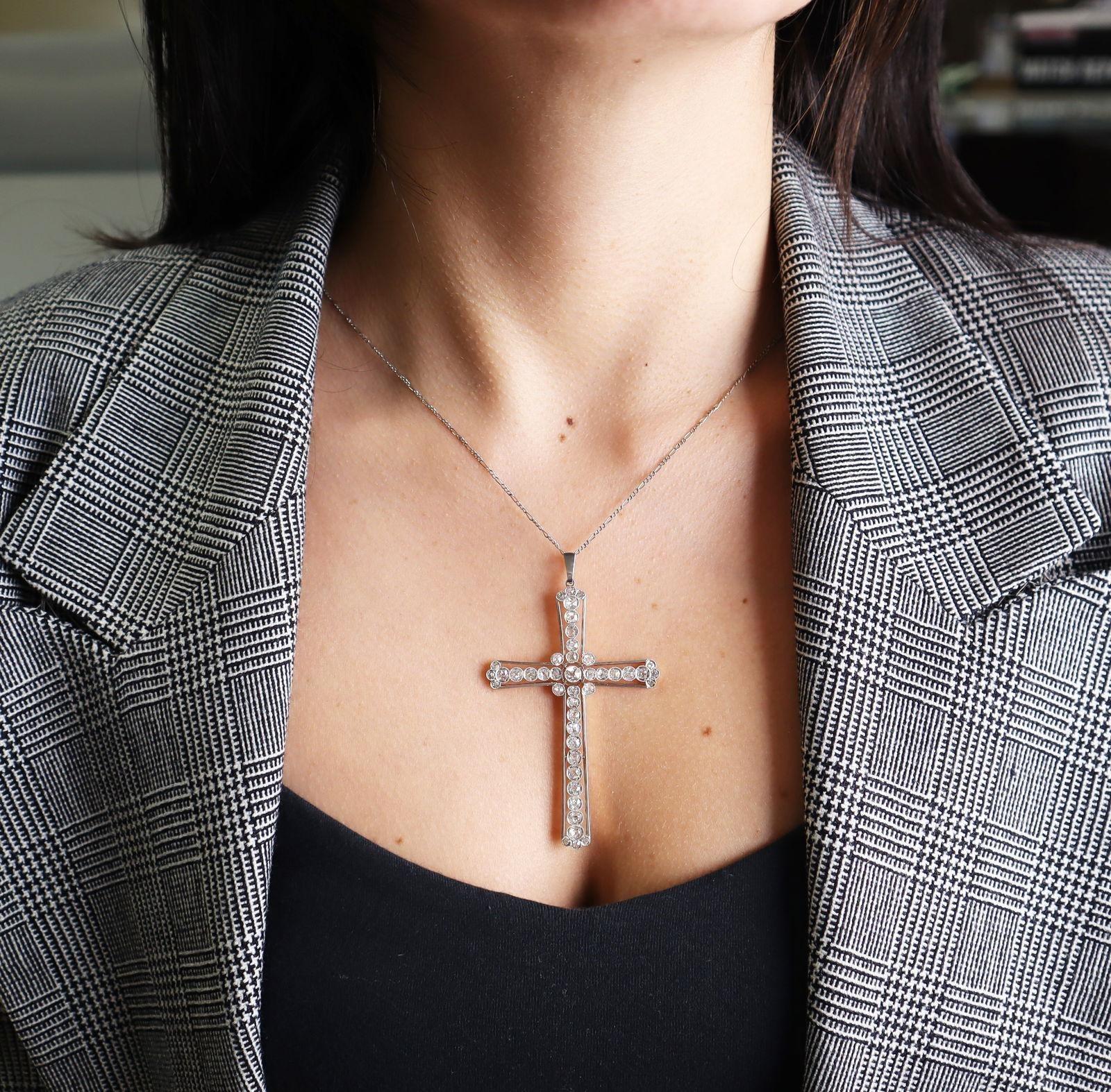 This stunning Edwardian cross pendant from the 1910s is expertly crafted in 18k yellow gold with intricate platinum millgrain details, showcasing the refined artistry and symbolic elegance of the era. The cross features 43 natural old mine-cut