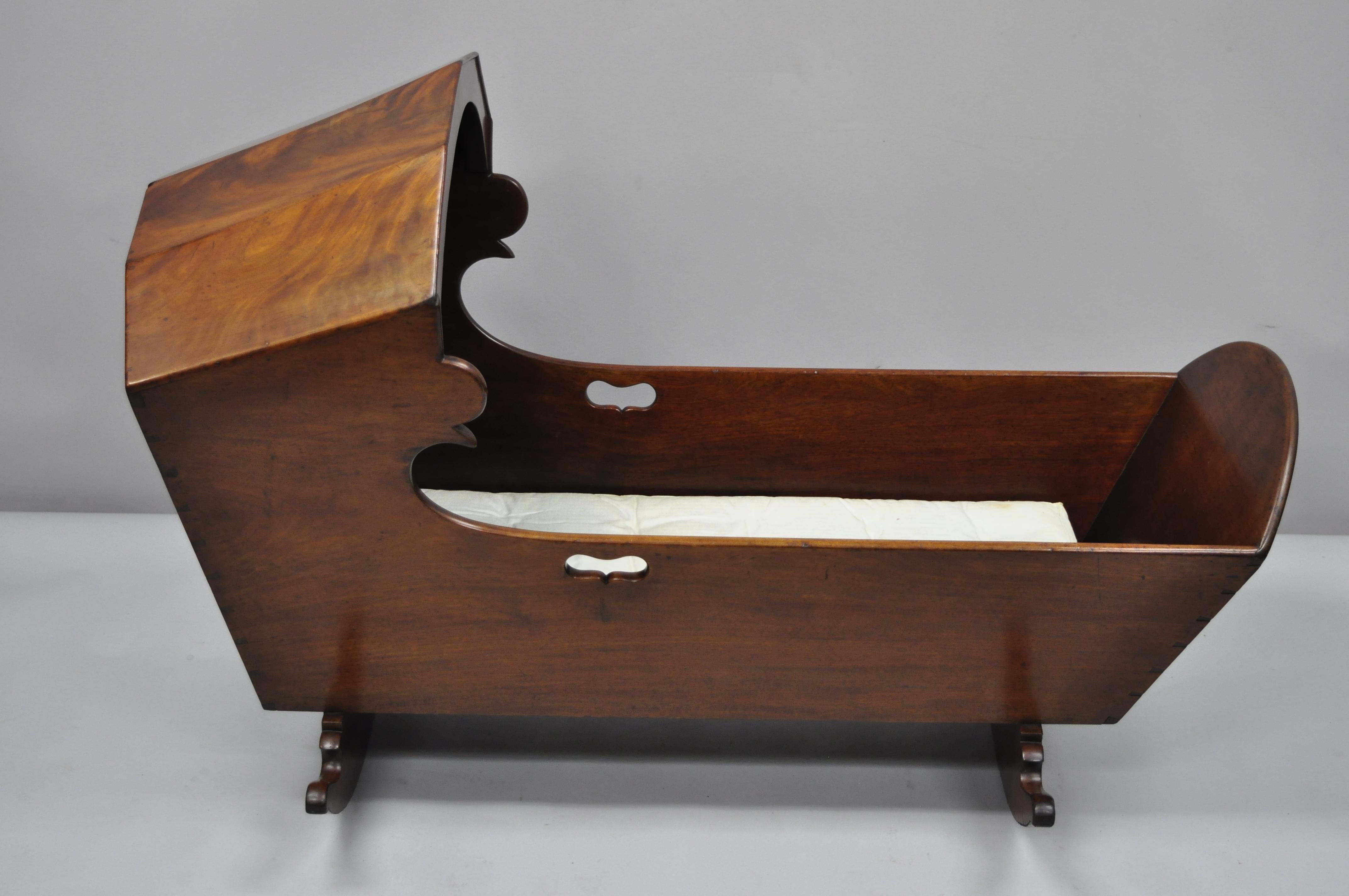 Antique crotch mahogany Victorian dovetailed baby bed cradle. Item features hand dovetailed construction, beautiful crotch mahogany woodgrain, very nice antique item, quality American craftsmanship, circa late 19th century. Measurements: 31