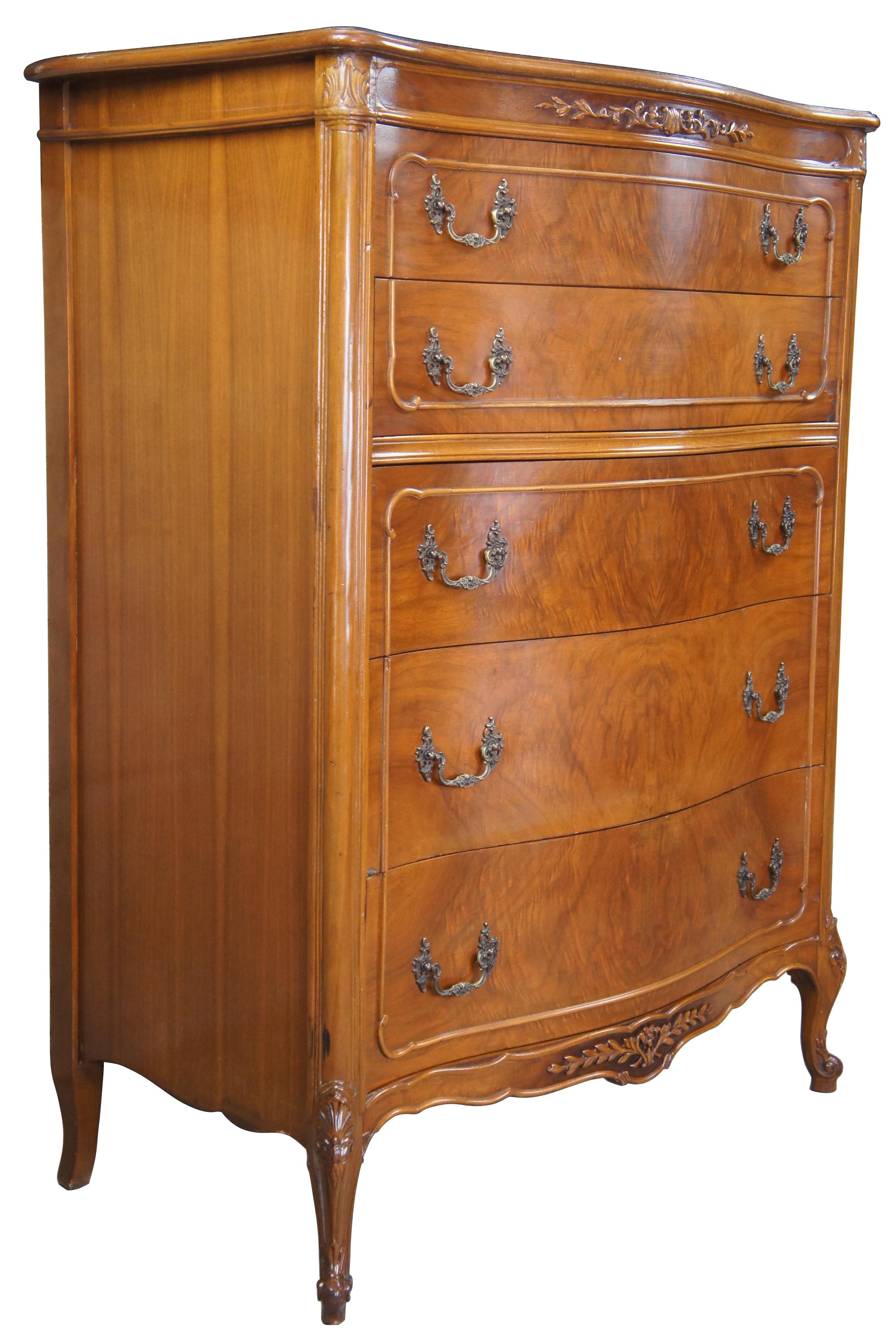 Circa 1940s French tallboy dresser or chest of drawers. Made from walnut with a serpentine front and crotch veneered drawers. Features carved accents, scalloped brass hardware, cabriole legs and glass top (not pictured).
   
