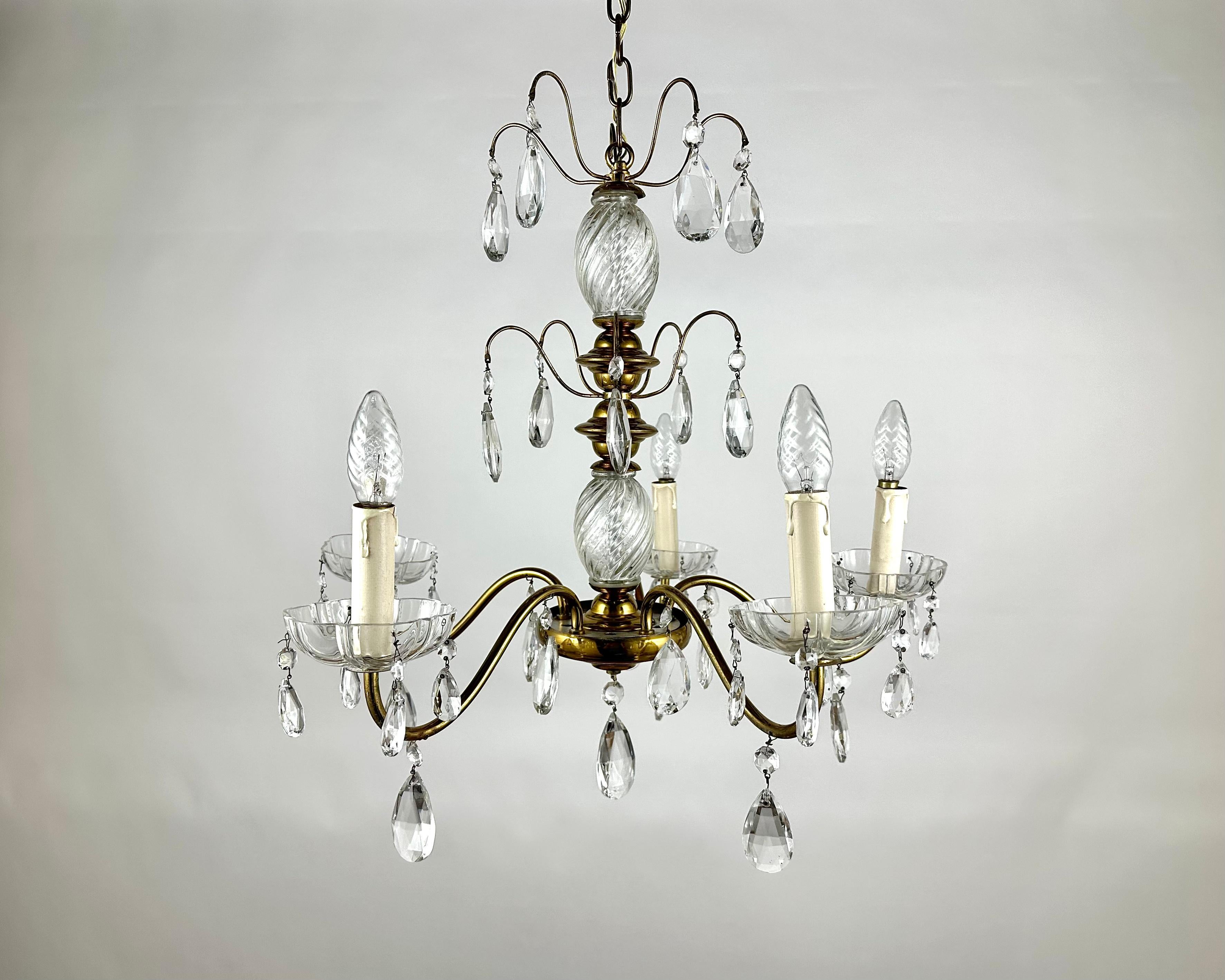 Circa 1920s Classic Style Chandelier with five light bulbs.

Manufactured in France.

Richly fecorated chandelier's framework is in gilt brass with transparent cut crystal decorations that capture and reflect the light of the bulbs.

This chandelier