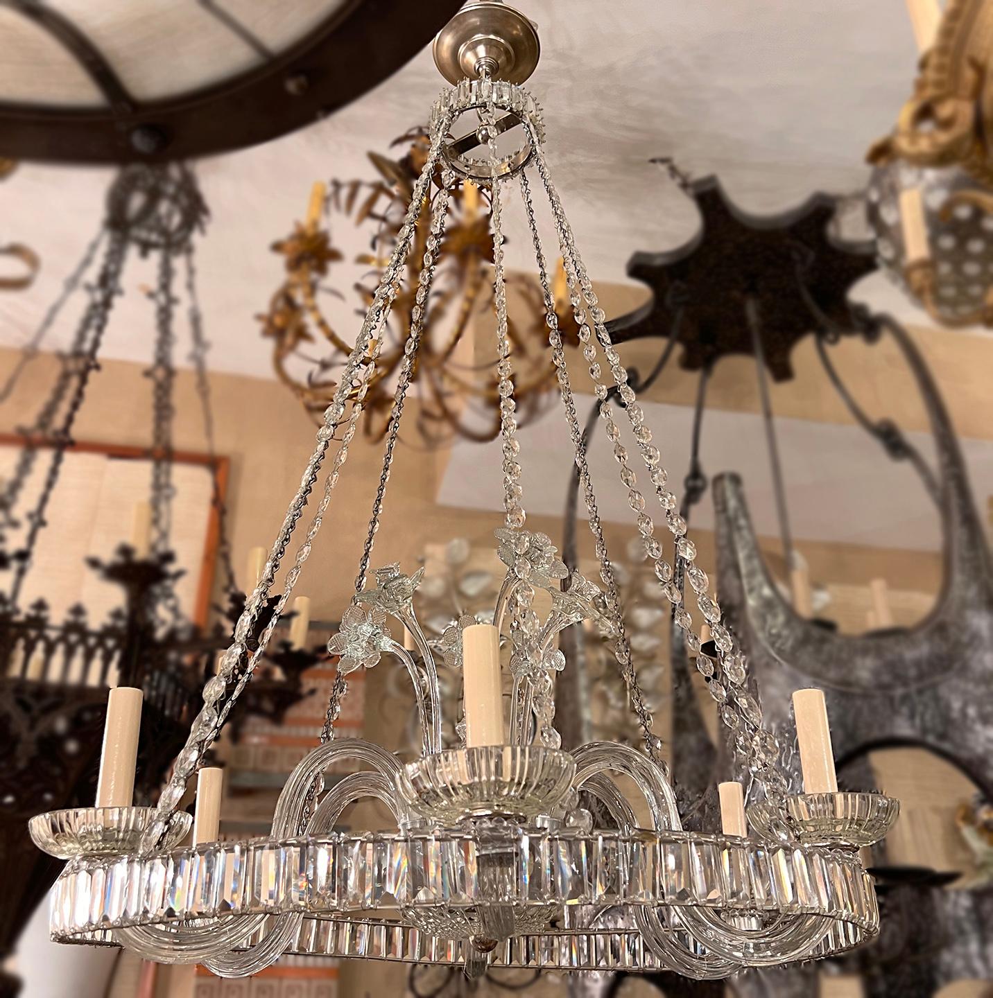 A circa 1920’s English six-light crystal Chandelier with a ring of crystals on the body and flower insets.

Measurements:
Diameter: 27