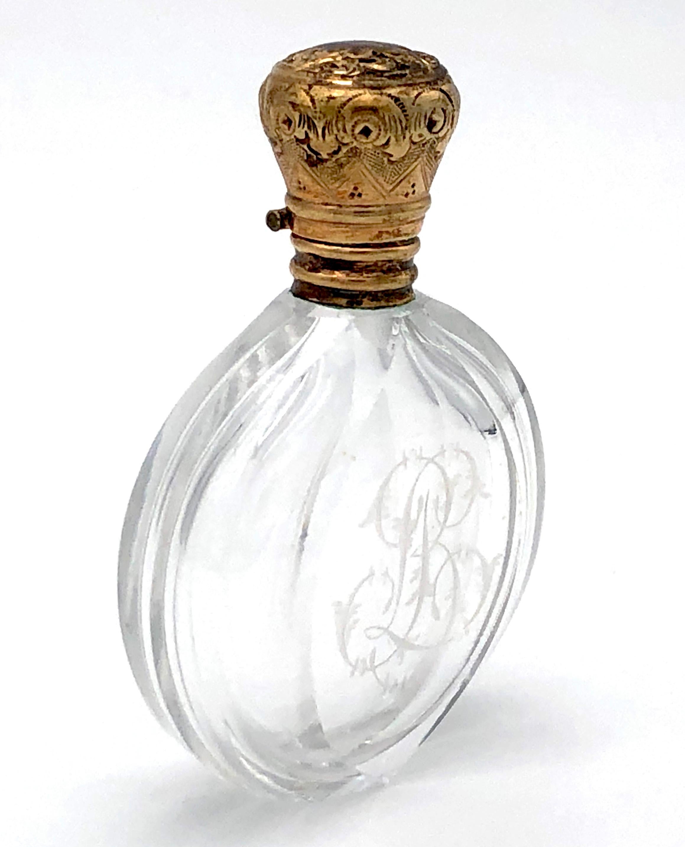 Charming and beautifully designed small gold mounted perfume bottle.
The exquisitely cut crystal bottle has the initial LB etched onto one side of the bottle .The opening of the bottle is covered with a ribbed gold mount and sealed of by a tiny 