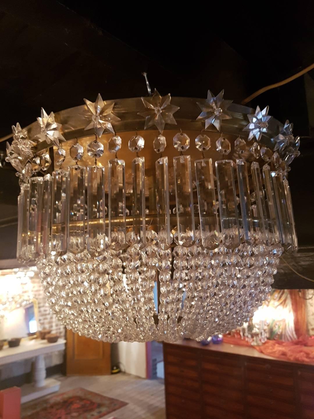 Beautiful French Plafonniere with beads of crystal. The top ring is decorated with star-shaped crystal ornaments and hanging long pendeloques. Inside the plafonniere there are four lights. At the bottom a large star-shaped crystal ornament secured