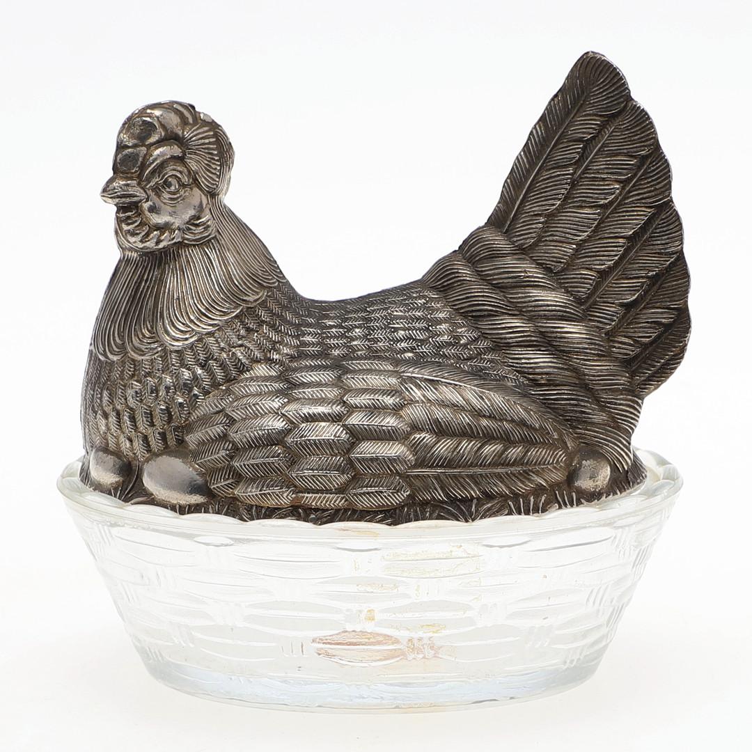 Antique argenté et cristal Porte oeufs de poule Farmhouse Country Home Decor Glaze VTG Dish. L'élégante poule peut servir de porte-œufs décoratif et s'ajouter à la décoration de votre cuisine.
Longueur env. 13 cm, hauteur env. 13,5 cm. Le bol en