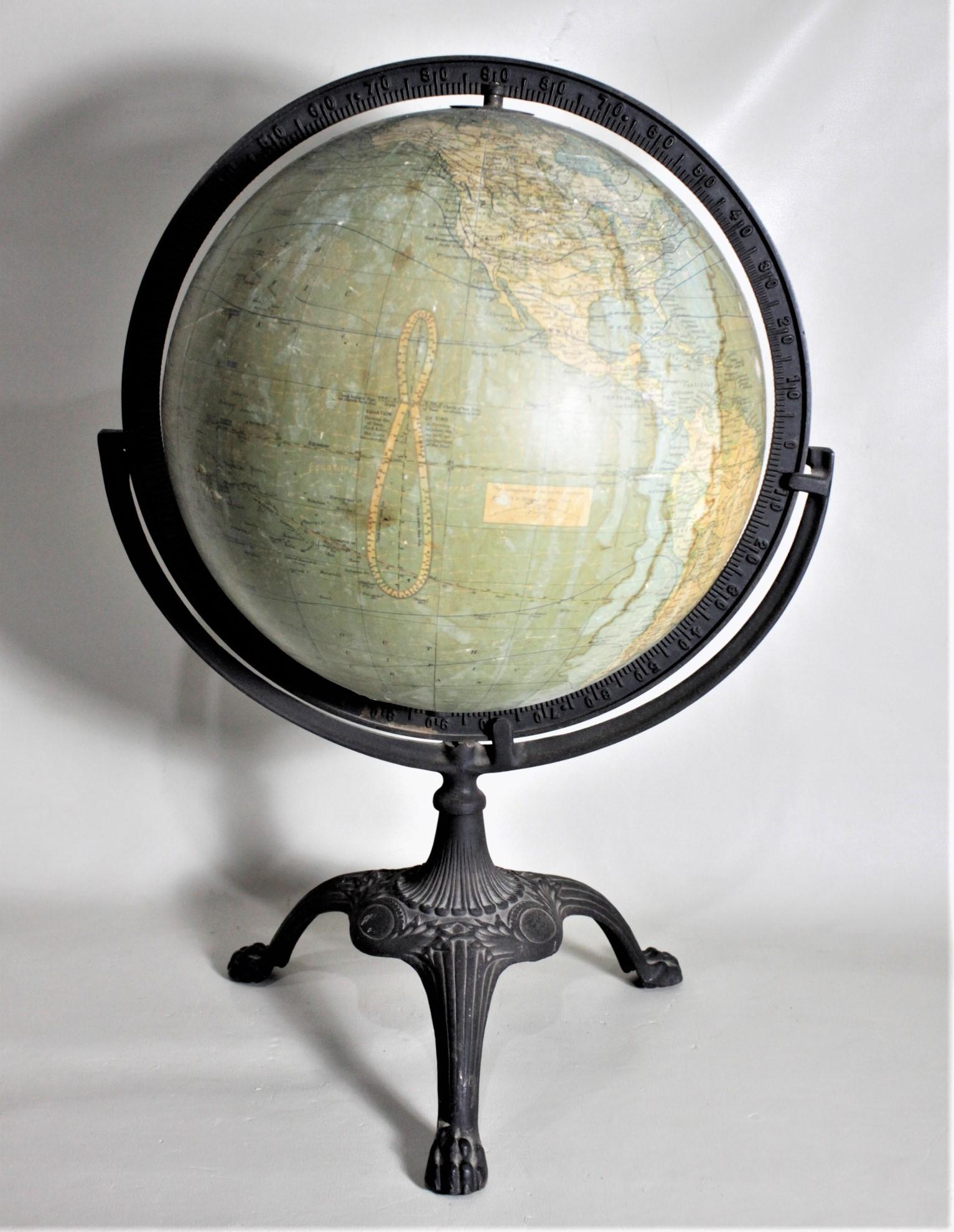 This antique desk globe was made by the C.S. Hammond & Co. of New York in approximately 1920 in the period Art Deco style. The globe sits inside a cast iron frame which rotates around, while permitting the globe to spin on its axis. The cast iron