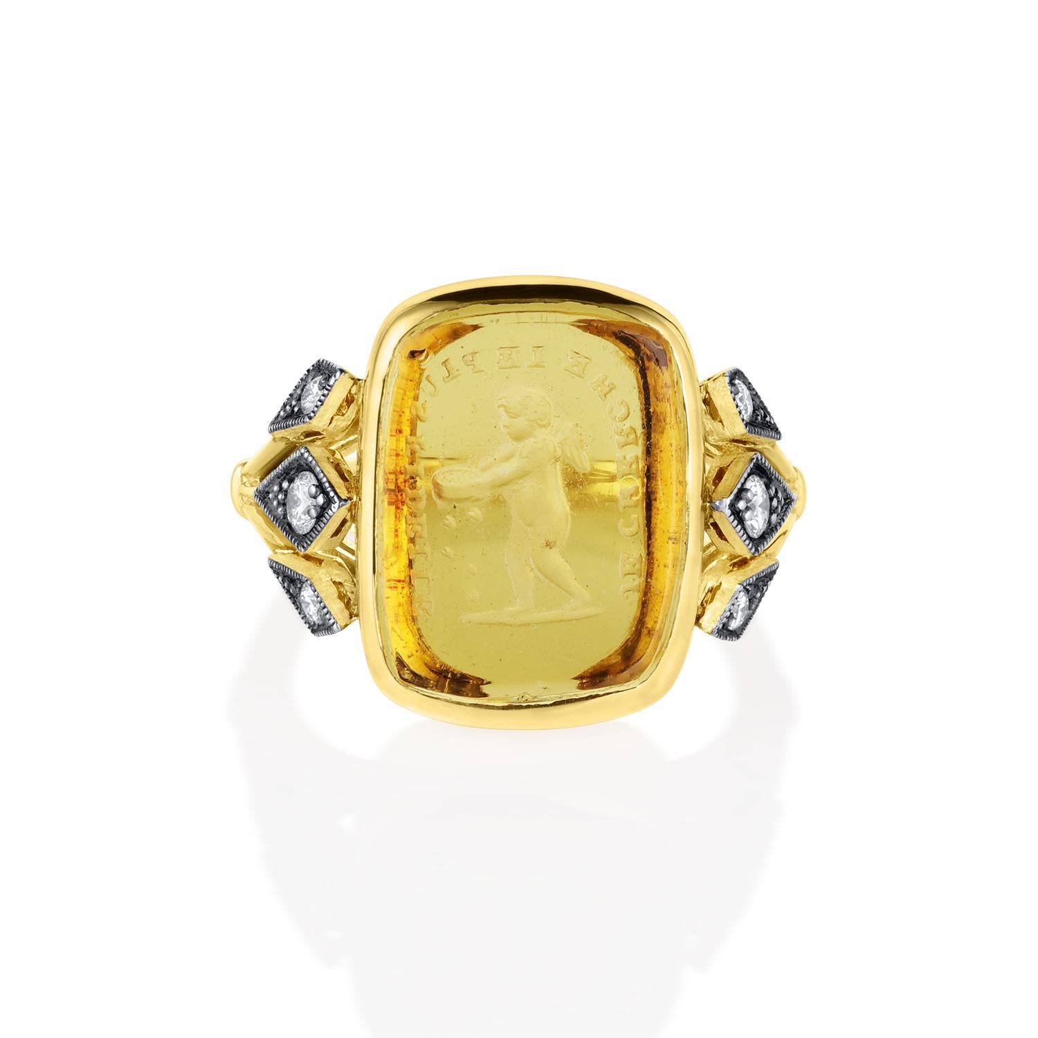 De notre collection Love Letters - célébrant l'amour sous toutes ses formes ! Cette bague enchanteresse est ornée d'un sceau antique en verre jaune (vers 1800) représentant Cupidon avec un panier de vannage, à travers lequel tombent de petits cœurs.