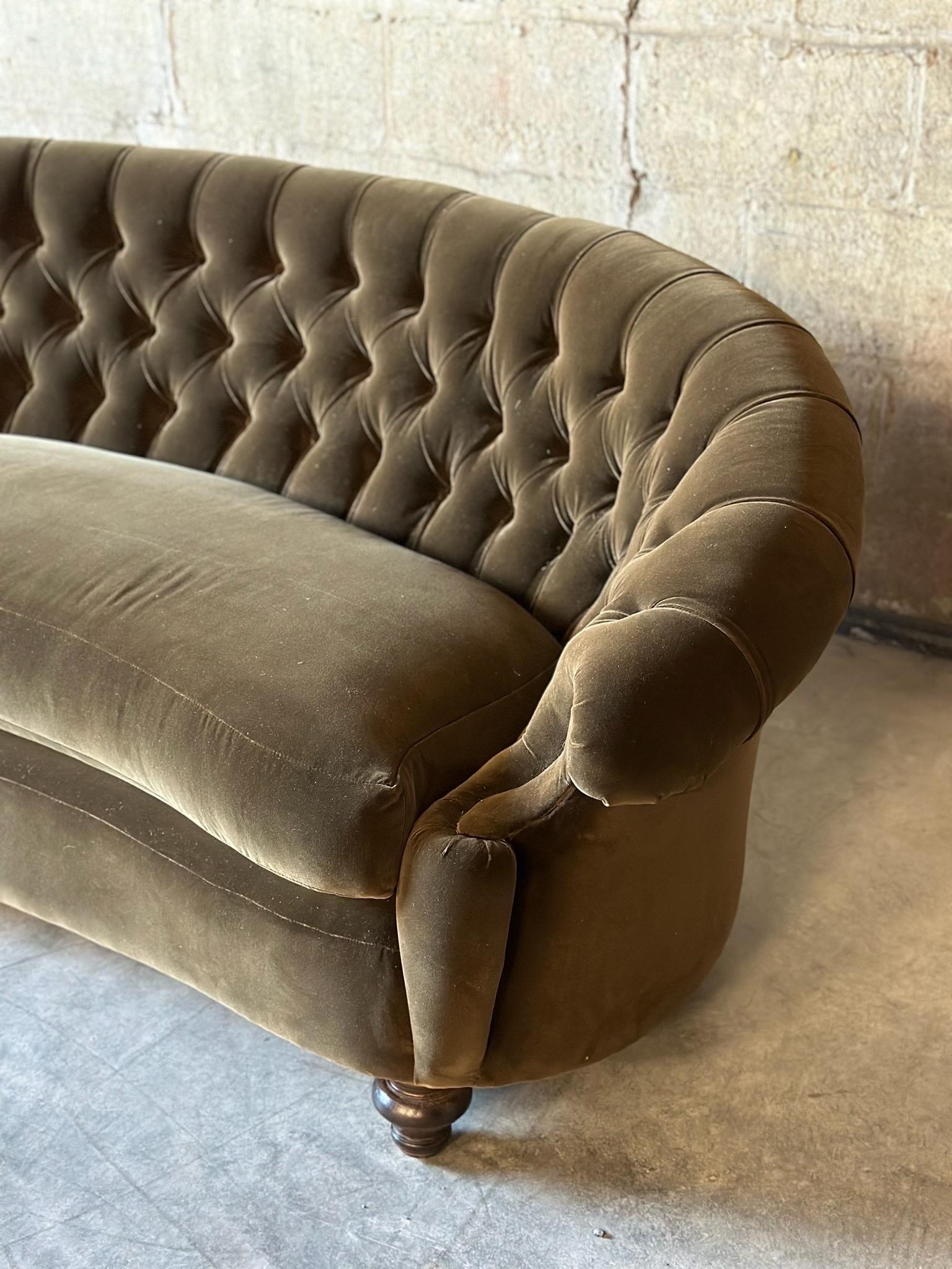 An Antique Curved Chesterfield. Recently recovered in exquisite dark green velvet and featuring a tufted seat back and custom
Down spring cushion.