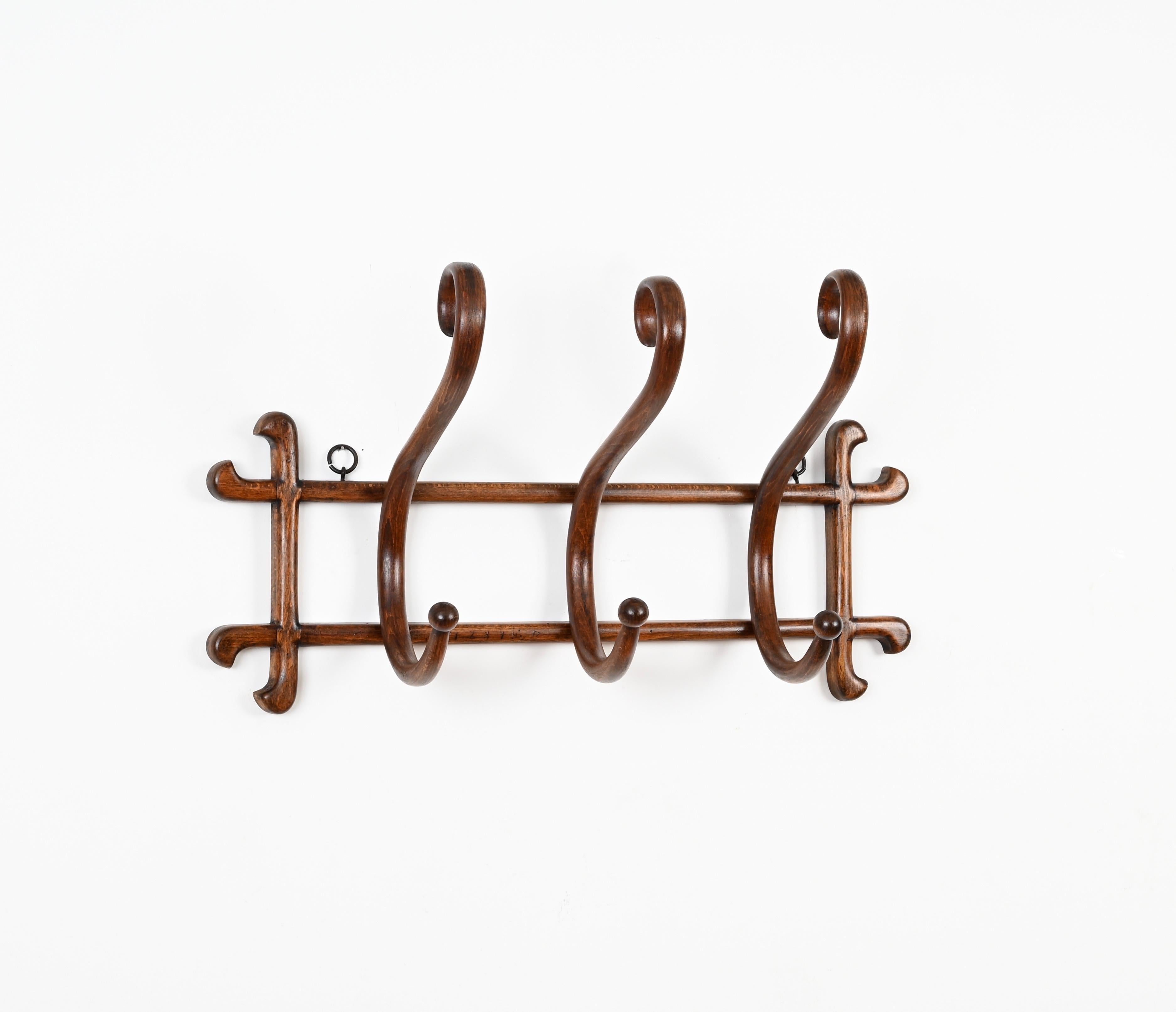 Magnificent Nouveau antique coat rack made in bent walnut wood. This charming piece was designed by Michael Thonet and produced in Italy in the early ' 900s.

In fabulous conditions and with a beautiful color, this coat rack has three curved arms in