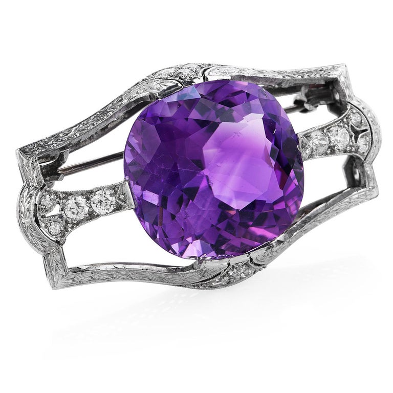 Meticulously crafted in platinum, this GIA-certified 1920's art deco antique amethyst brooch of dramatic presence will accentuate your best outfits.  

Crafted in platinum, the large cushion amethyst of approximately 17.50 carats is held in a prong