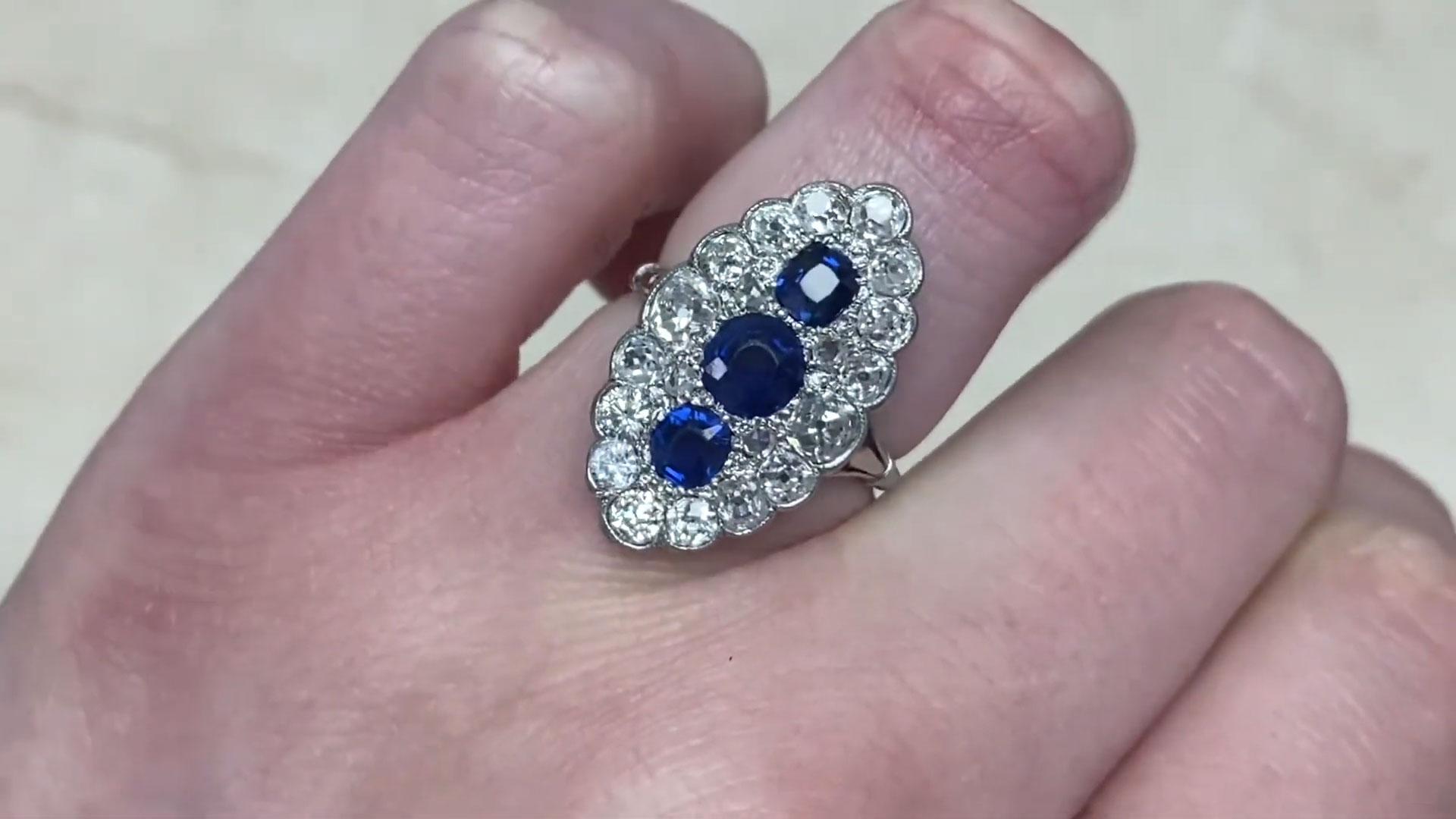 An exquisite Edwardian ring, handcrafted in platinum circa 1910, featuring a stunning trio of natural sapphires pave-set in a graceful north-south orientation. The sapphires, totaling approximately 1-carat, include a central round-cut stone flanked