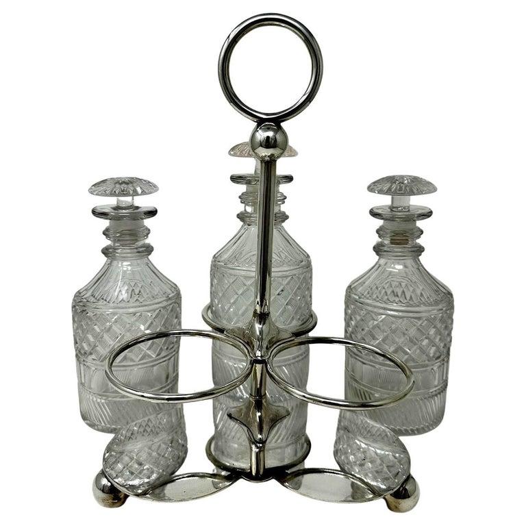 A Superb Sheffield Silverplated Three Bottle English Spirits or Wine Tantalus, complete with its original full led hand cut crystal decanters, of exceptional quality, late Nineteenth Century. 
Each decanter is hand cut depicting strawberry cut