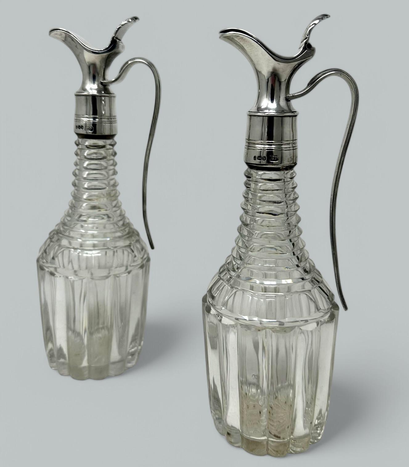 Impresionante pareja de aceiteras y vinagreras inglesas de cristal tallado a mano y plata de ley, de extraordinaria calidad, principios del siglo XIX. 
Cada botella de cristal de plomo tallado tiene un contorno tradicional con un cuerpo principal de