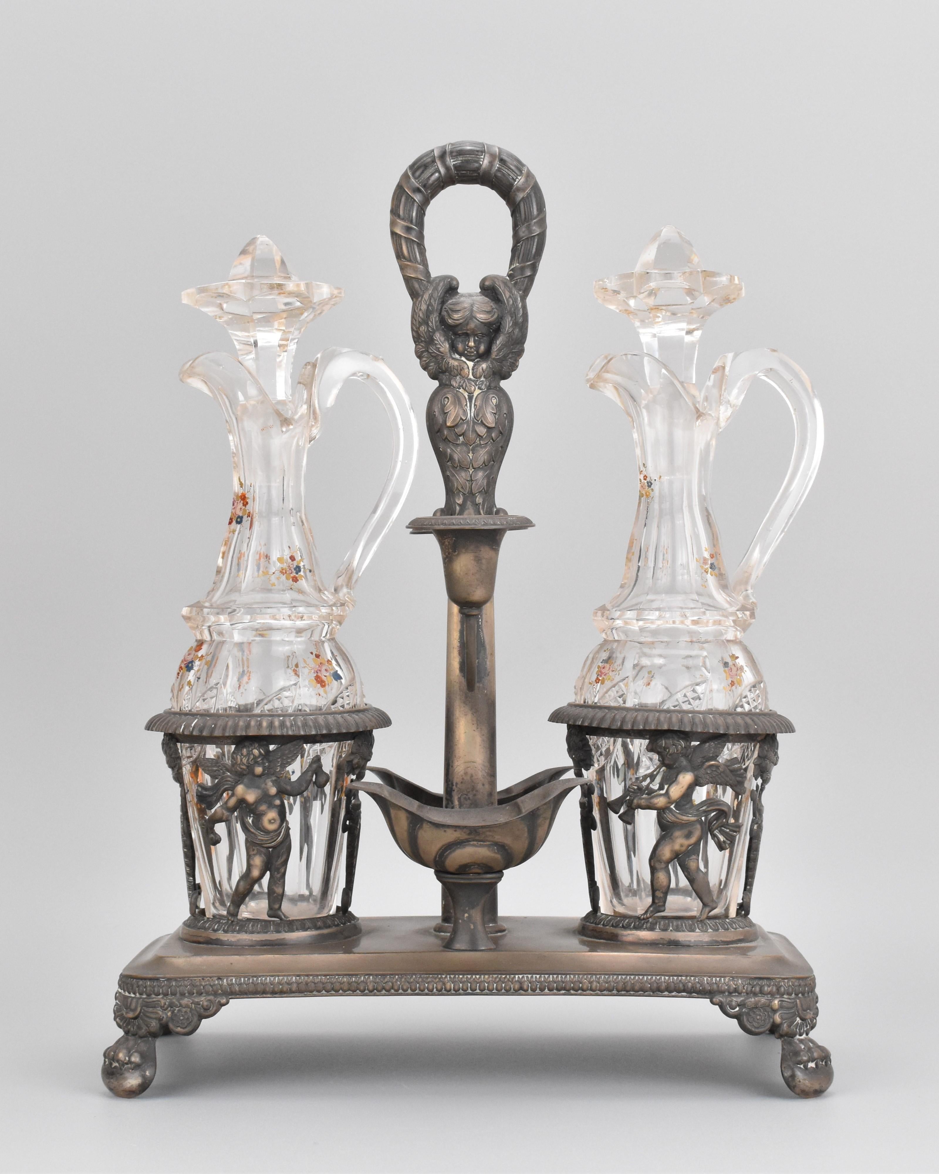 Questo antico set di oliere e aceti, risalente alla fine del XIX secolo, è un superbo esempio di artigianato francese, che combina un'elegante lavorazione del vetro e un'intricata arte del metallo. Il set è composto da una coppia di cappe in vetro