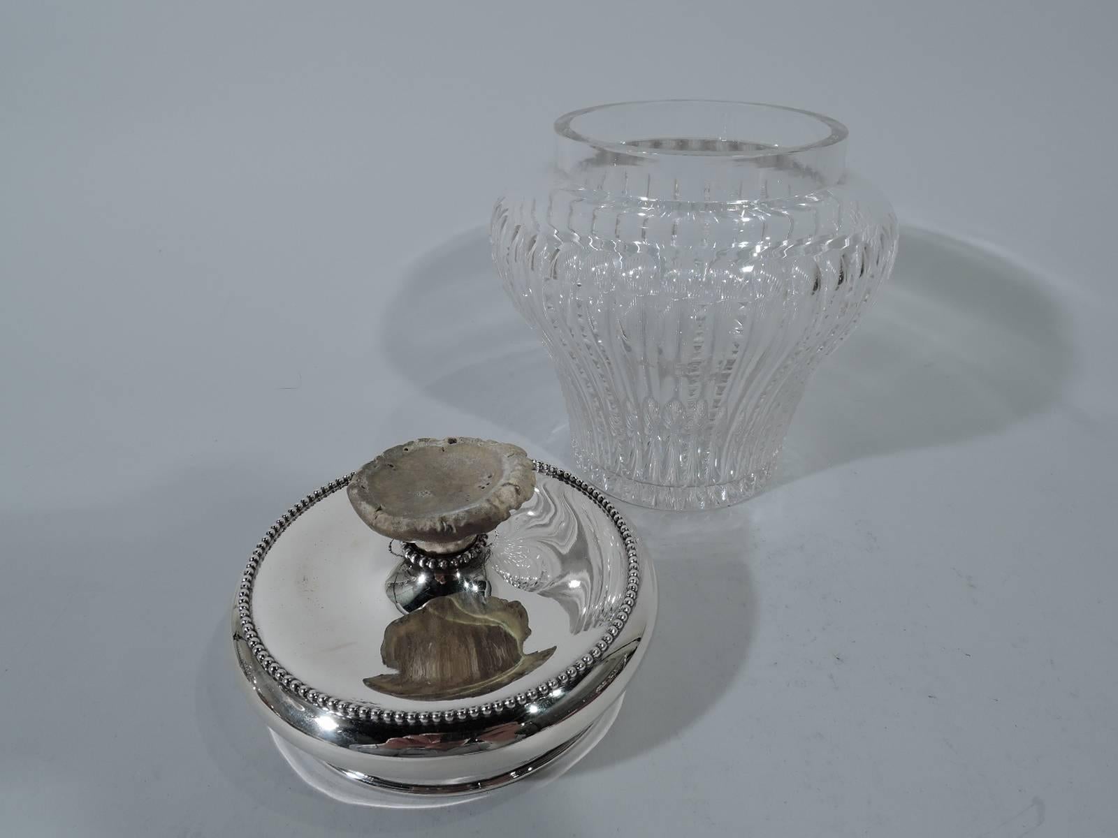 Edwardian cut-glass tobacco jar with sterling silver cover. Made by Redlich & Co. in New York. Jar ovoid with three plain flutes alternating with one notched flute and underside star. Cover has bellied sides and flat top with applied beading and