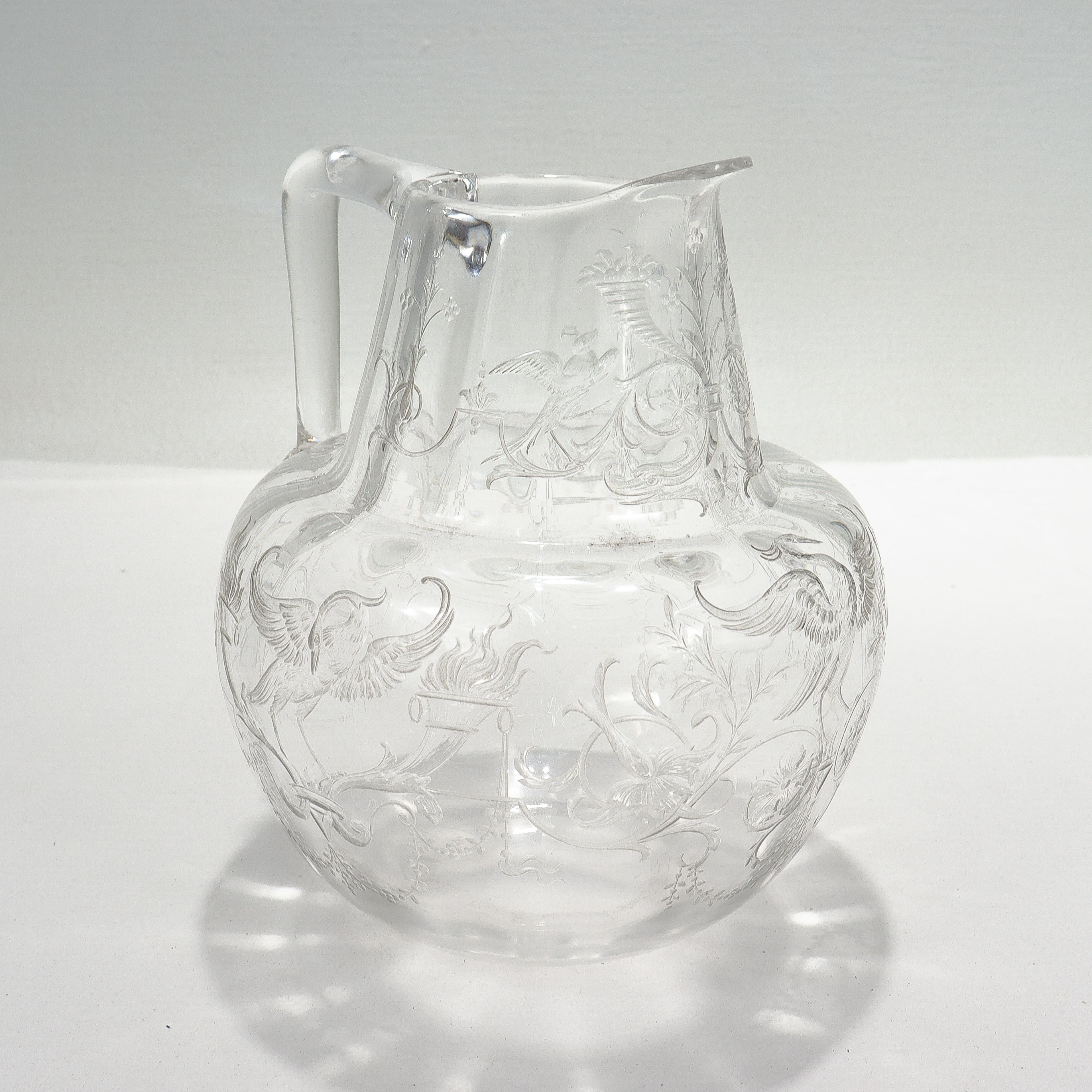 A fine antique English cut glass water pitcher.

Attributed to Stevens & Williams.

In a water or juice pitcher size.

Engraved with designs of phoenixes, birds, cornucopia, flowers, and trellis work.

Simply a wonderful antique Stourbridge