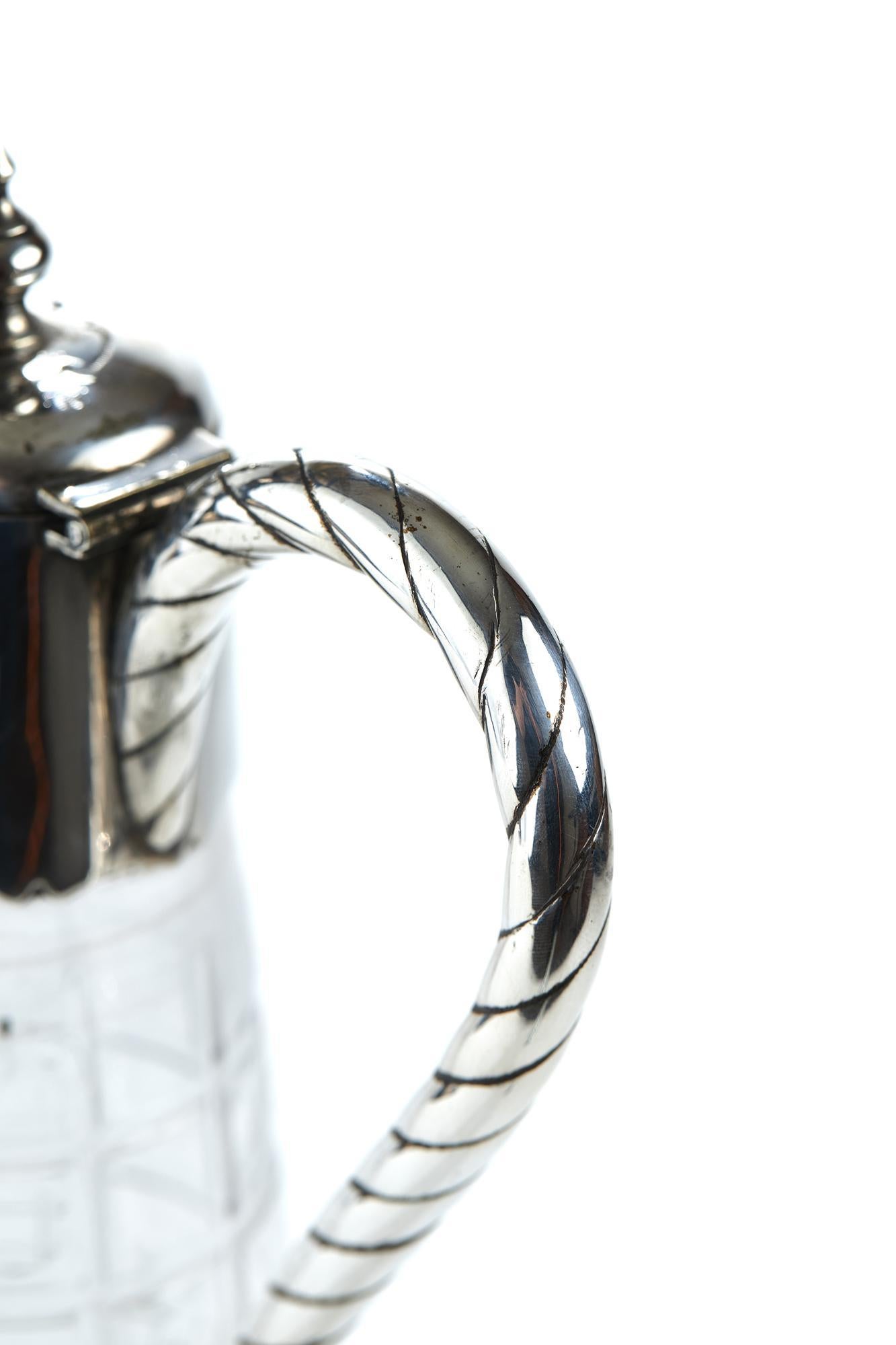 Antique Cut Glass Silver Plated Mounted Claret Jug, the glass bottom of tapering outswept design having an unusual cut glass square design, mounted by a beautifully decorated silver plated top with rope twist handle terminating in a heart shaped