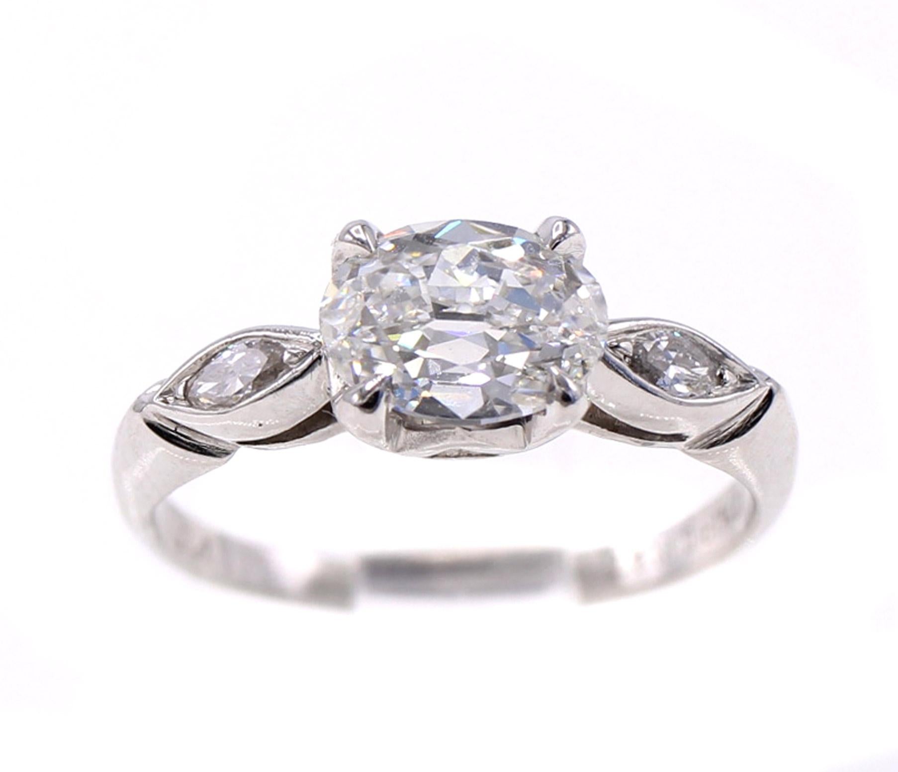 The centerpiece of this well handcrafted contemporary mounting is a beautiful antique cut oval diamond weighing 1.01 carats accompanied by a report from the GIA grading the color as F and the clarity as VVS2. The interesting combination of 2 periods
