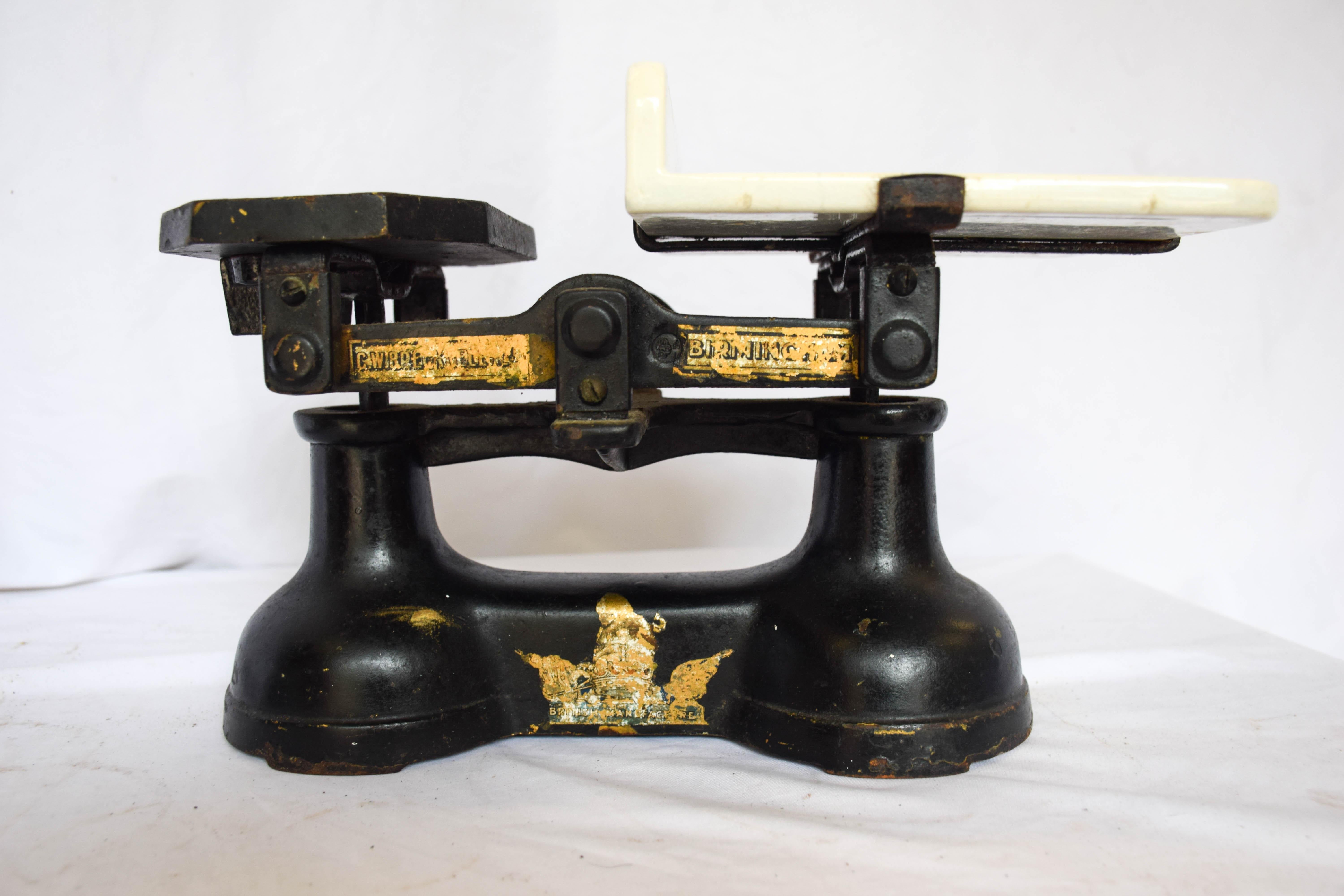 Wonderful English Countertop scale in black cast iron from the C.W. Becknell scale company in Birmingham England. This functioning kitchen scale with weights has a beautiful milk ironstone embossed with Justitia Virtutum Regina which means the Queen