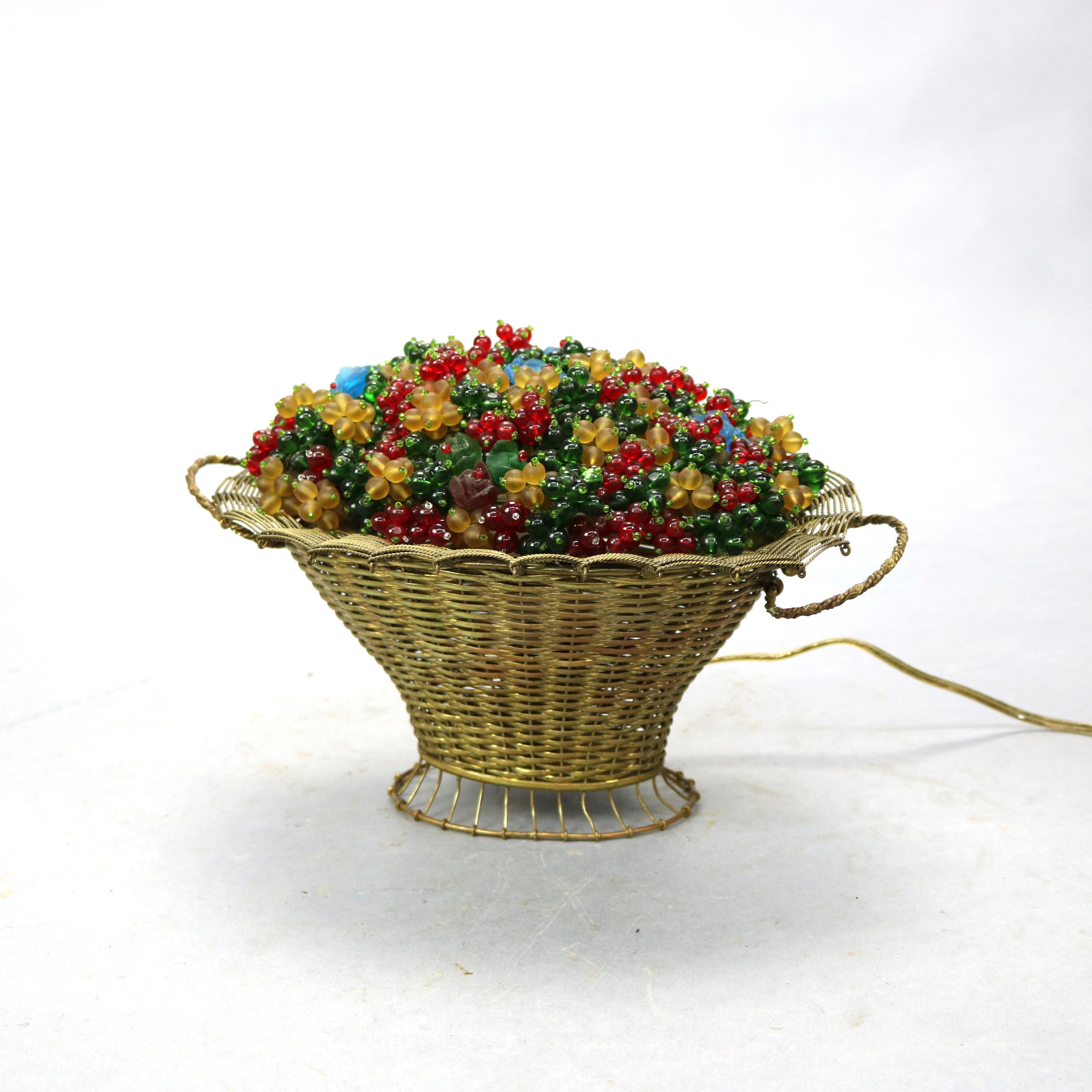An antique Czechoslovakian Panier de Fleurs (Basket of Flowers) table lamp offers a woven brass basket with interior light illuminating art glass beaded flowers, c1920

Measures - 8'' H x 11.5'' W x 8'' D.