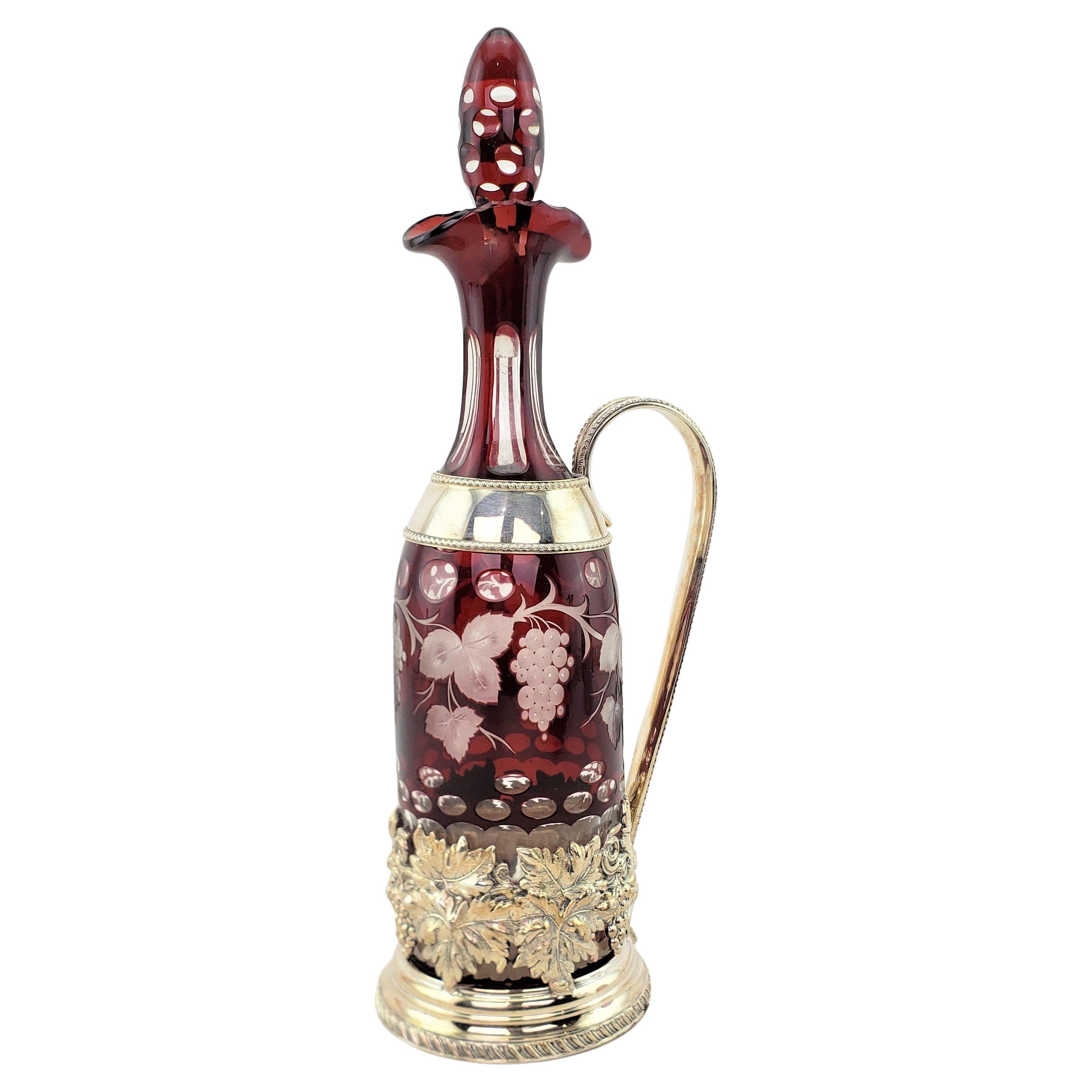 Carafe tchèque ancienne en forme de bouteille transparente taillée en rubis avec support en métal argenté orné