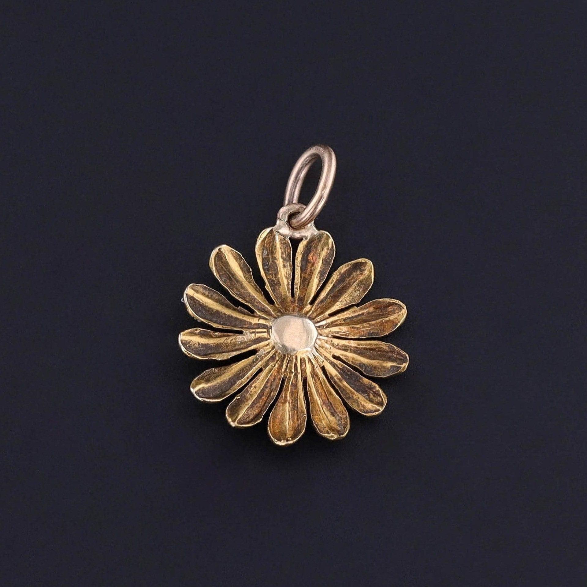 Le margherite sono storicamente un simbolo di purezza, innocenza e amore leale e vengono comunemente portate dalle spose nel giorno del loro matrimonio.

Questo charm antico presenta una margherita in oro 14k ornata di smalto bianco. In origine si