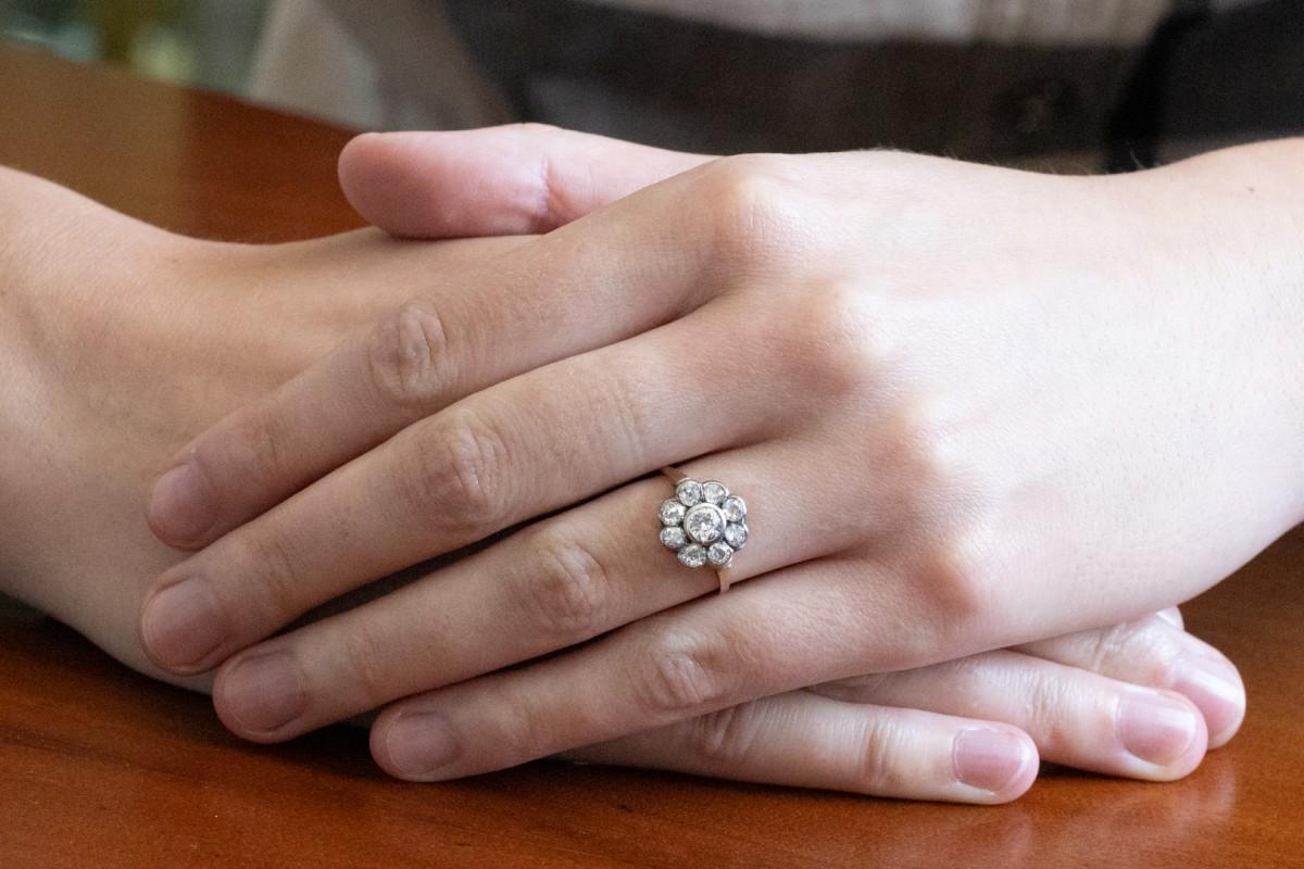 Bague marguerite avec des diamants anciens de taille brillant.

Bague marguerite avec des diamants anciens de taille brillant sertis en argent sterling entre un délicat anneau d'or jaune 14 carats (0,585 de finesse).

Bague ancienne avec des
