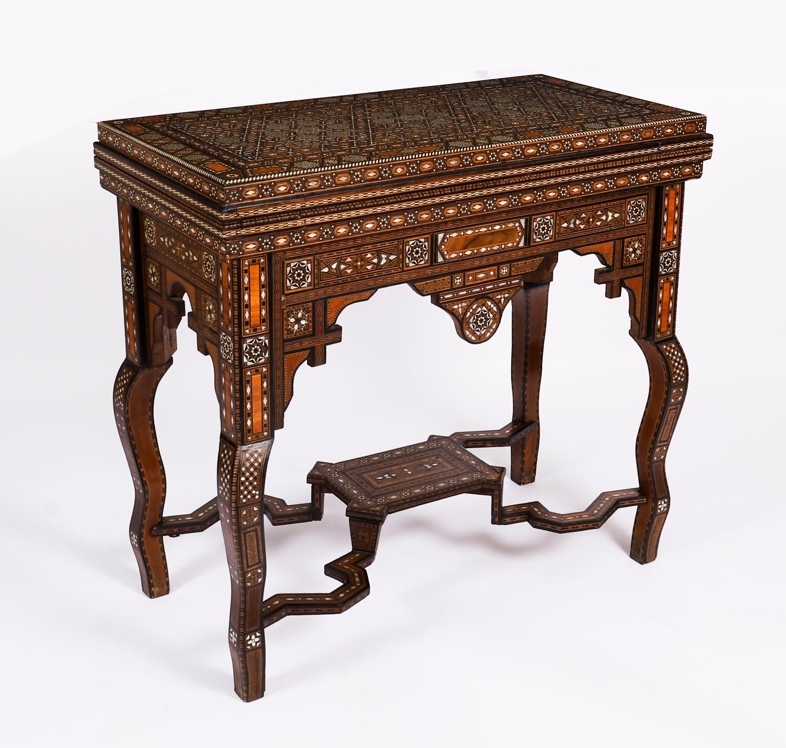 This is a profusely inlaid Syrian Damascus games table that dates from Circa 1880, and has  multiple geometric and asymmetric inlays of various specimen woods.

The hinged lid opens to reveal a similarly inlaid interior and a fold over reversible