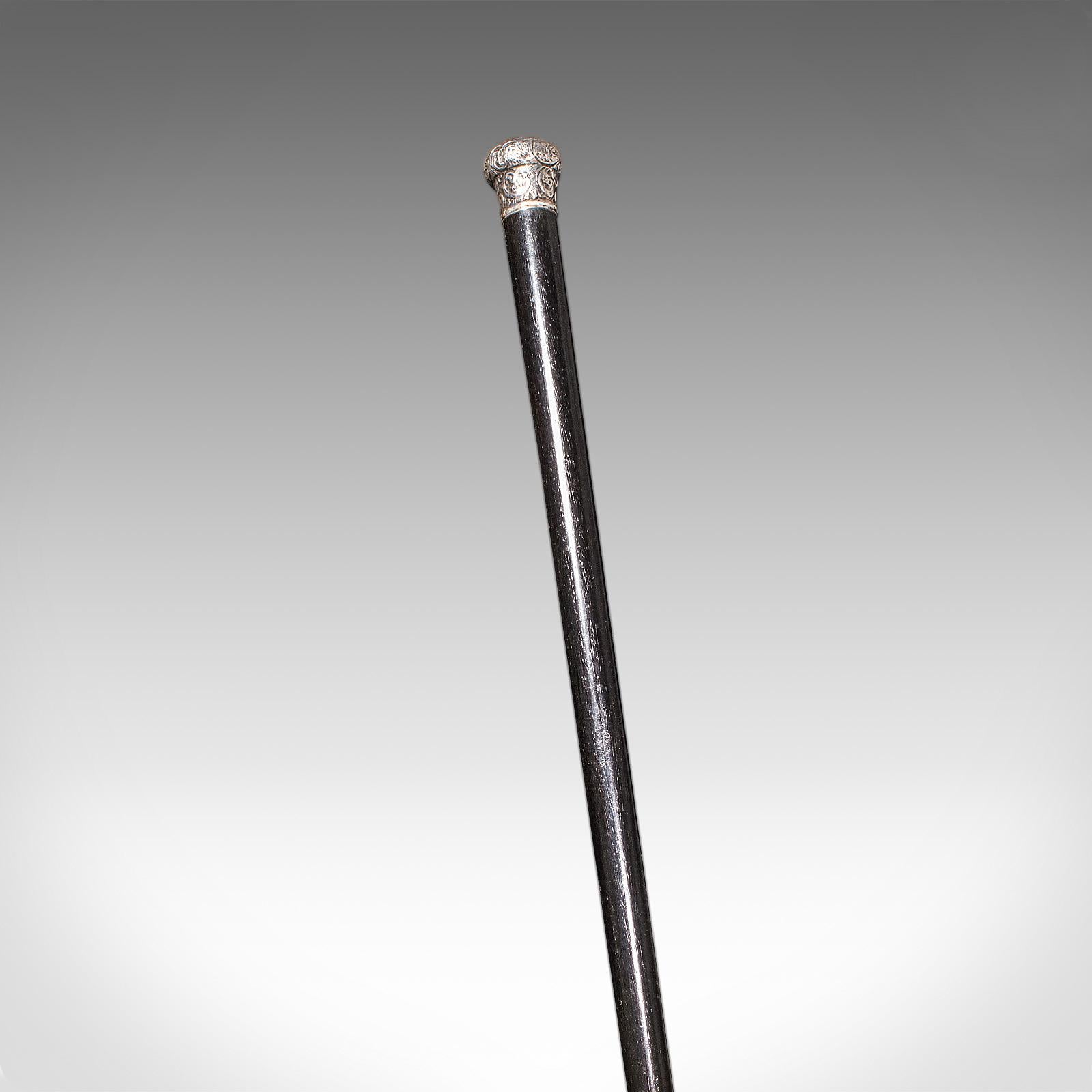 Il s'agit d'une ancienne canne de Dandy. Un bâton de gentleman anglais en acajou ébonisé avec une poignée en argent, datant de la fin de la période victorienne et poinçonné en 1889. Un superbe accessoire de raffinement et de goût, dégageant charme