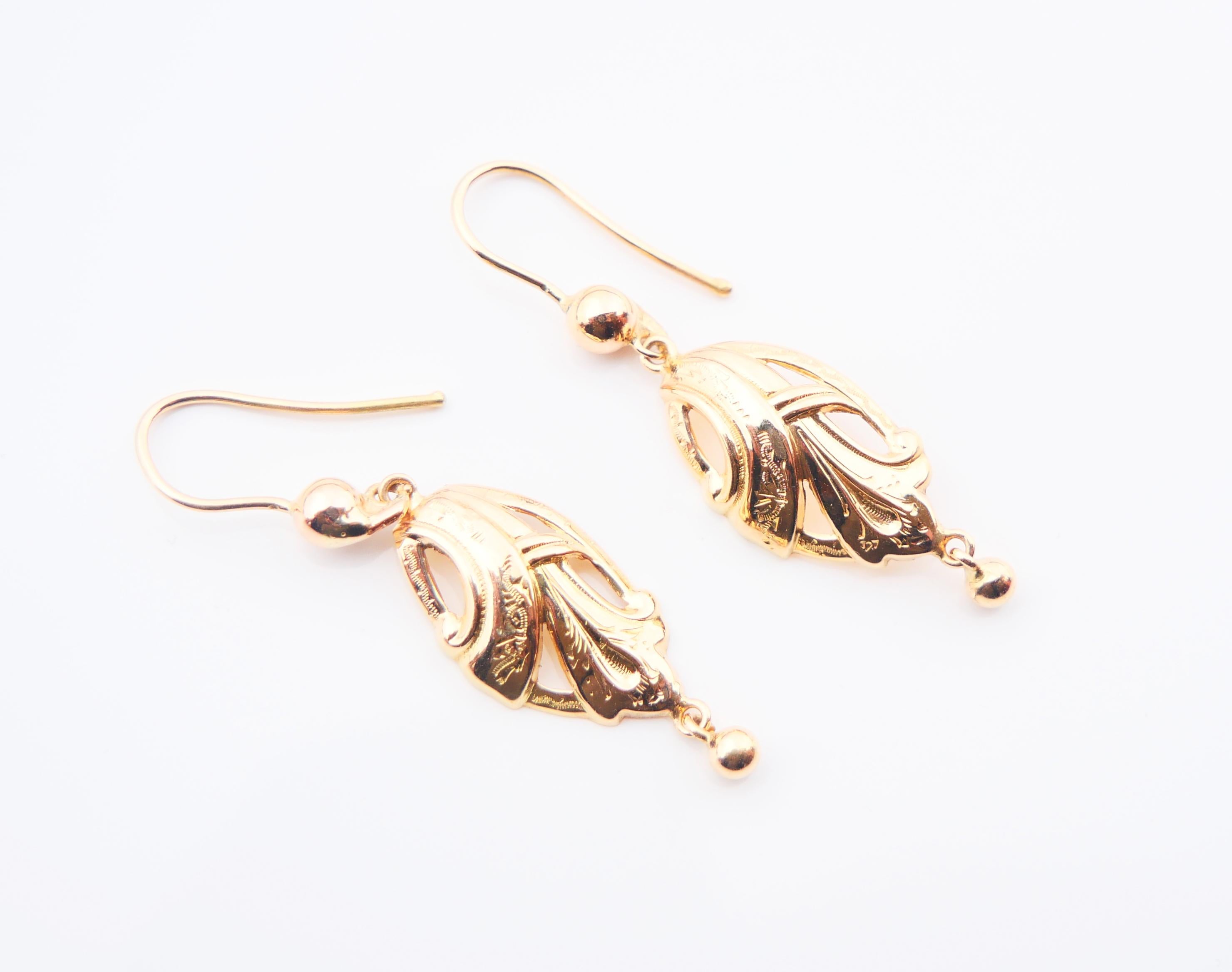 A  pair of beautifully shaped and engraved dangles in solid 18K Yellow Gold.

Both dangling parts are freely suspended. Not hallmarked, made ca. 1900s -1930s .

Each earring is  42 mm long (including hooks) x 11 mm at widest. Each round dangle Ø 3