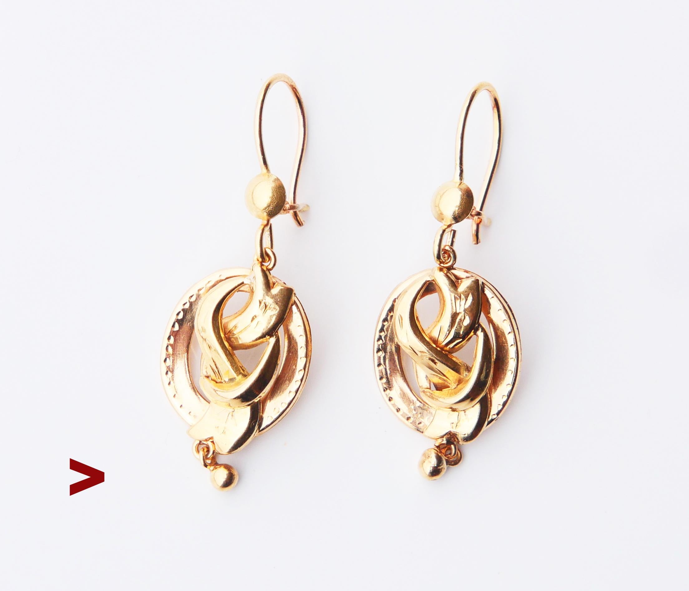 A pair of antique earrings with bodies designed as knots in solid 18K Yellow Gold. Both engraved with ornaments, terminated with freely suspended drop shaped dangles.

Made ca. 1920s -1930s , such designs were popular in Europe in late 19th - early