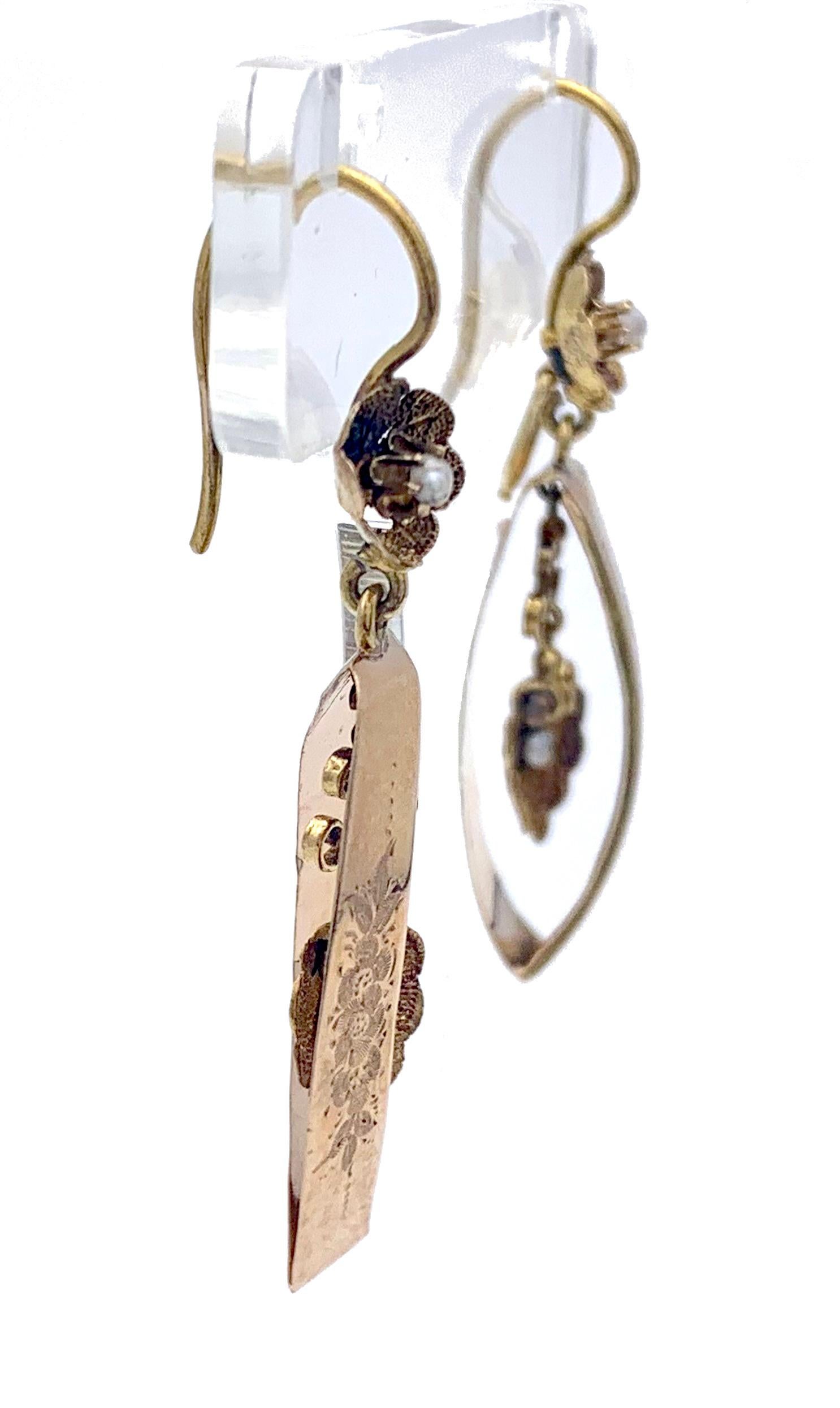 These unusual dangling earrings have been fandcrafted out of 14 karat rose gold in 1845 ca. The earrings are designed as a pair of ellipses hanging from little flowers. Inside the ellipses two articulated scallops are suspended adding extra movement
