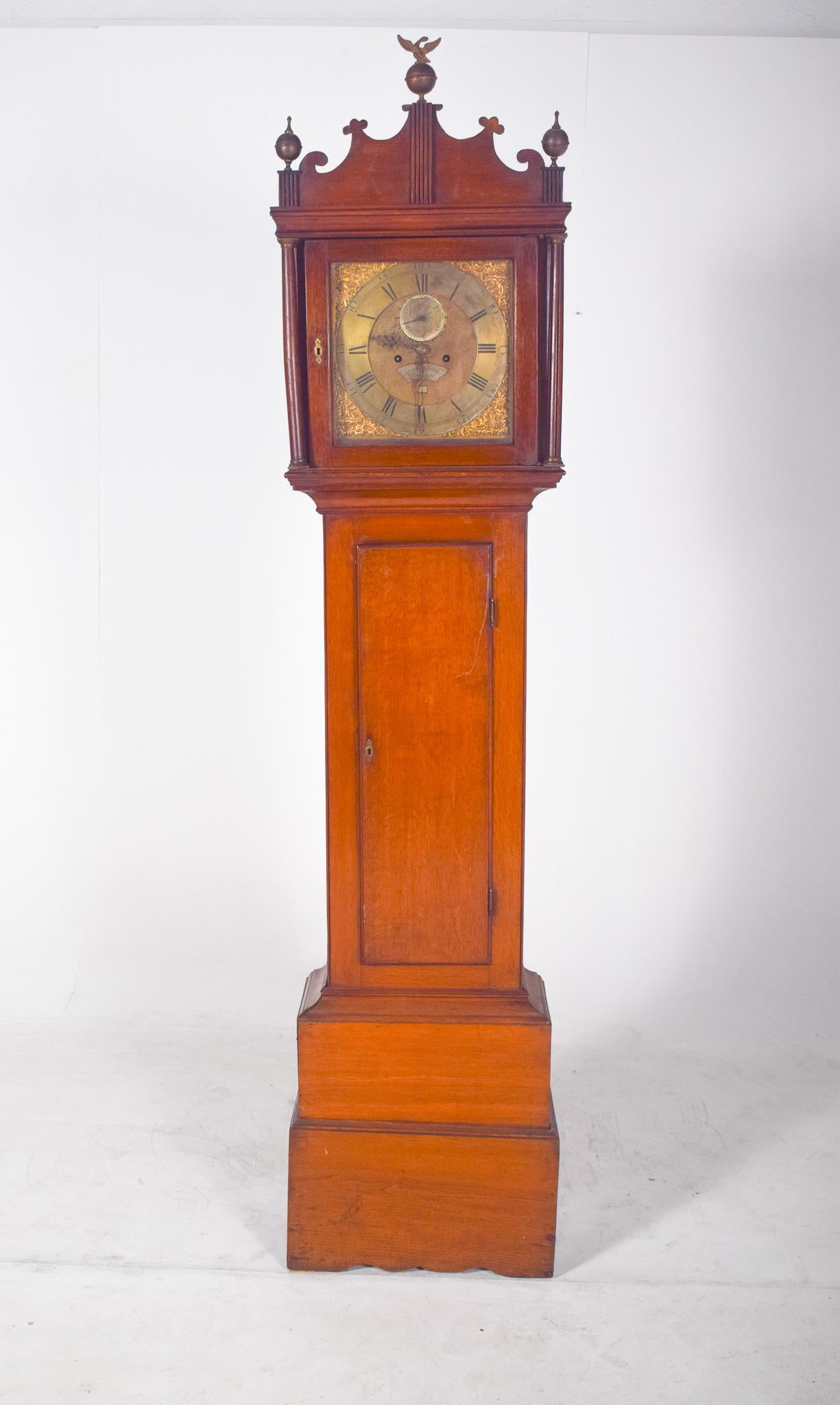 Uhr mit großem Gehäuse, Daniel Bing. Vertikal imposant und klassisch raffiniert, ist die Uhr aus warm getöntem Holz gefertigt, mit geraden, einfachen Linien auf dem Gehäuse, die im Kontrast zu dem kunstvollen oberen Teil stehen, wo sich das
