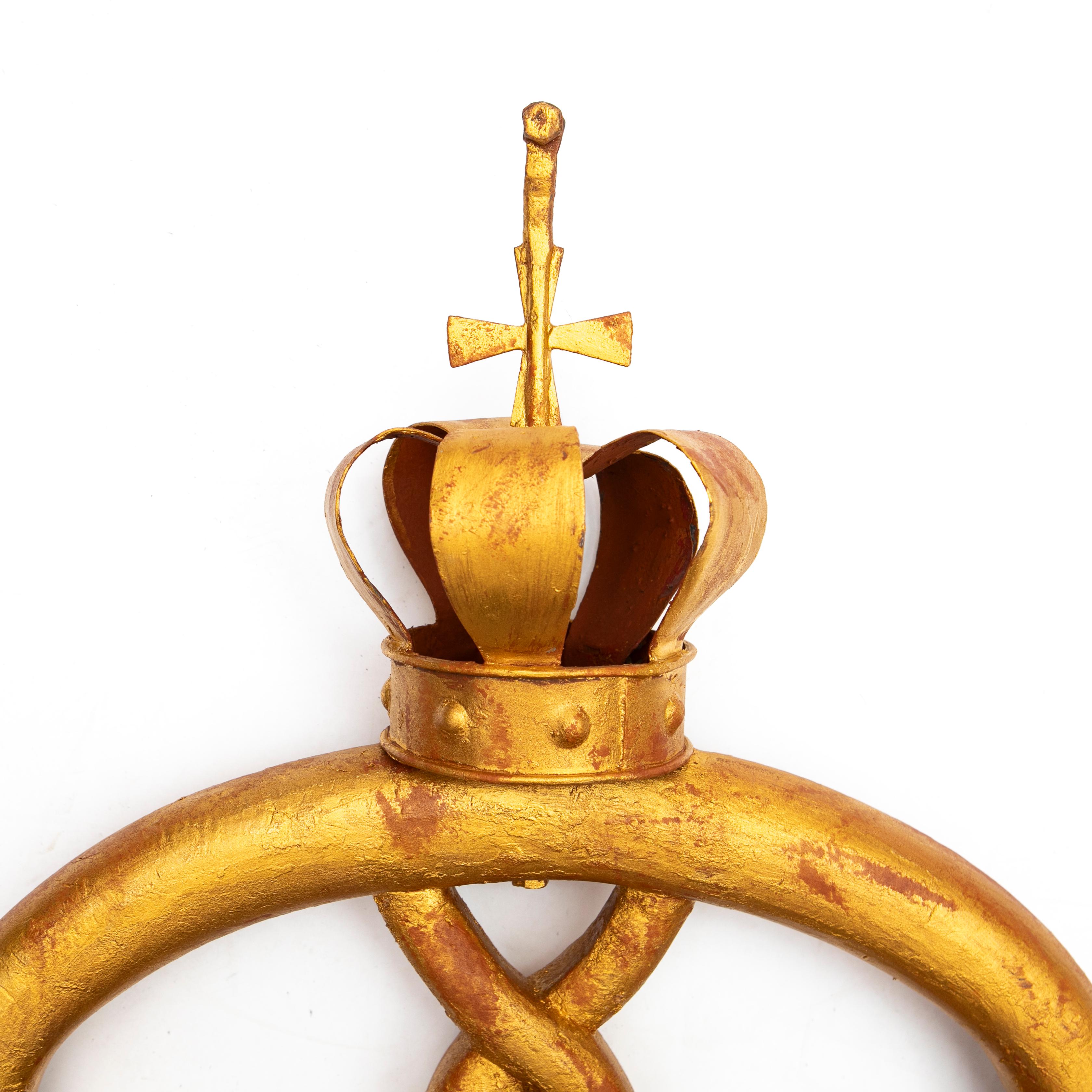 A large antique baker's pretzel shop sign from Denmark, approx. 1900.
The pretzel is carved wood with gold leaf finish on a red base and topped metal crown and cross.

Originally this sign would have hung from an arm extended out near the exterior