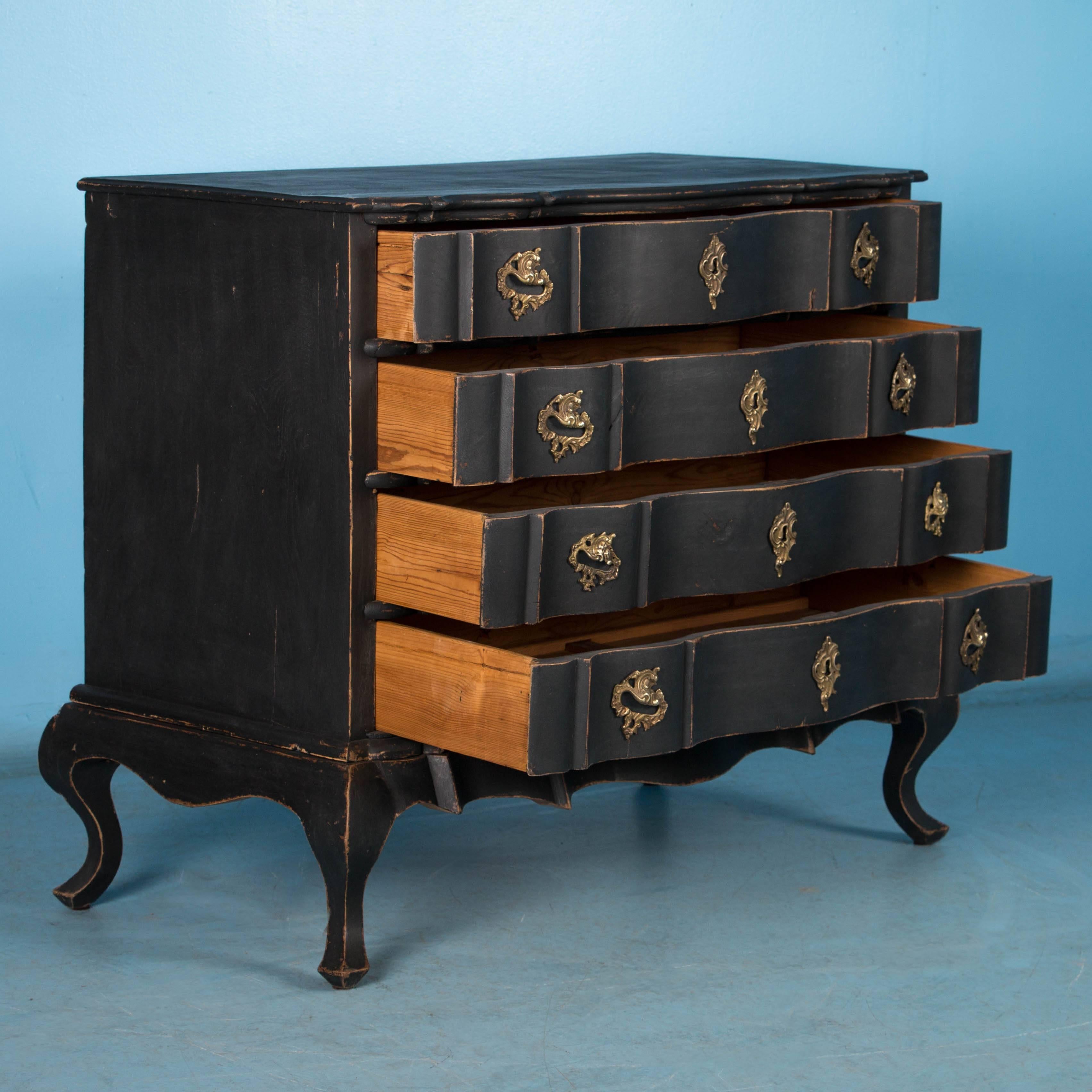  The strong visual appeal of this handsome Danish chest of drawers is due to the new, lightly worn black chalk paint that accents the contours of the top and each of the serpentine drawer fronts. Where the paint has been gently scraped, the rich